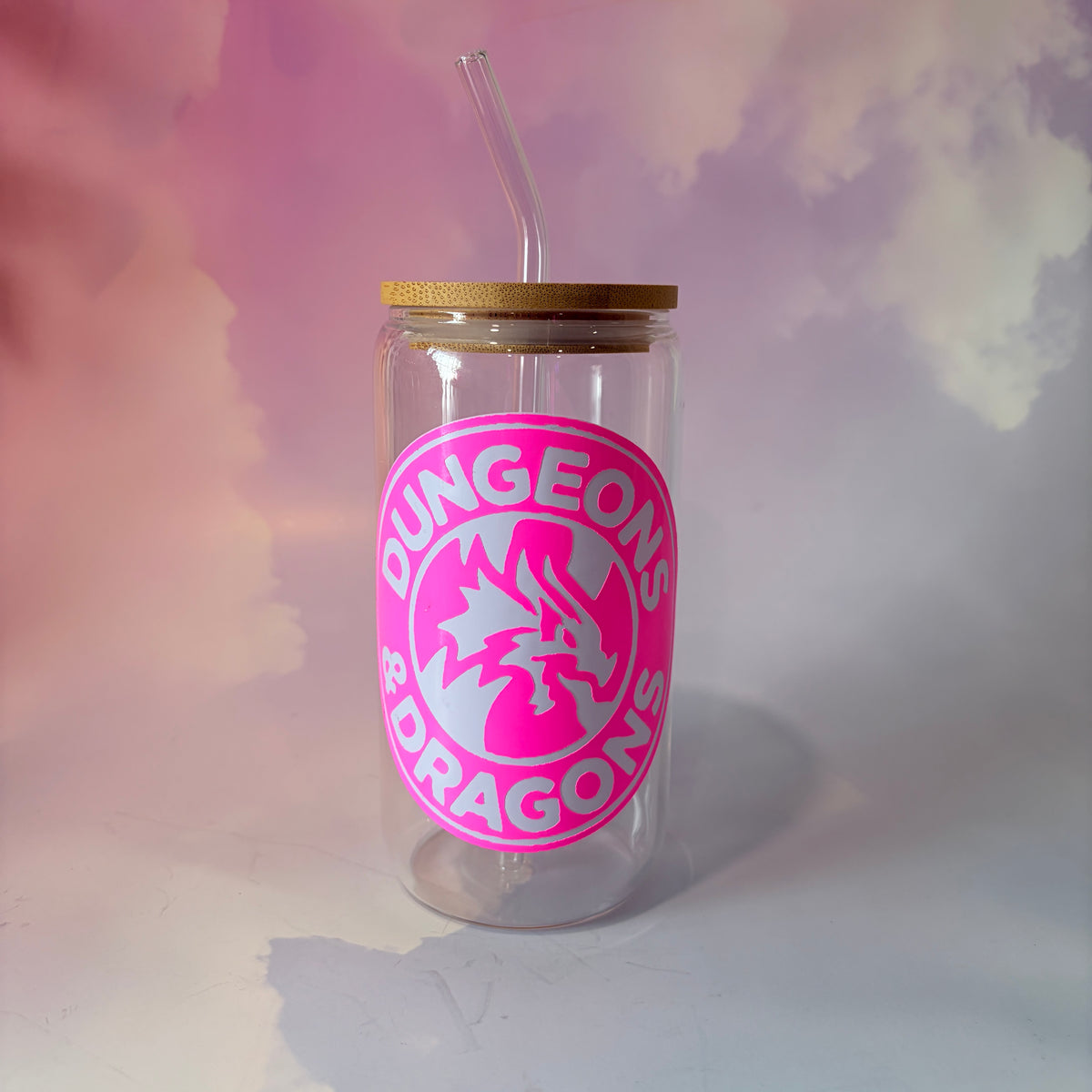 16 oz Dungeons and Dragons glass coffee can with vinyl fantasy design, bamboo lid engraved with two D20 dice, and straw. Custom colors available. Handwash only; not dishwasher or microwave safe.