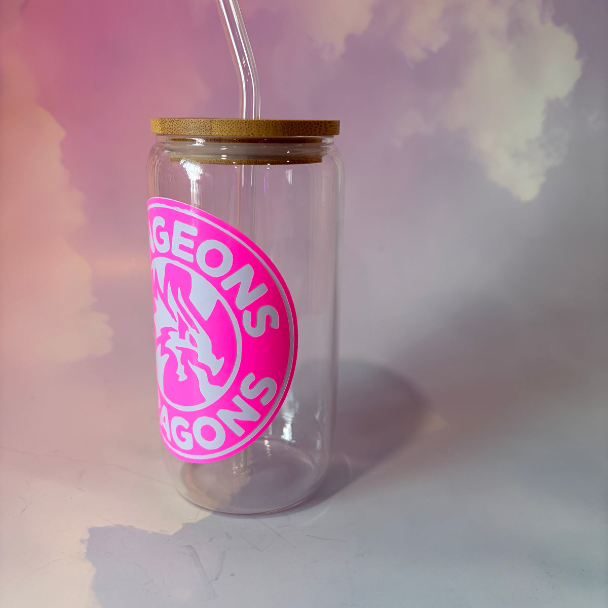 16 oz Dungeons and Dragons glass coffee can with vinyl fantasy design, bamboo lid engraved with two D20 dice, and straw. Custom colors available. Handwash only; not dishwasher or microwave safe.