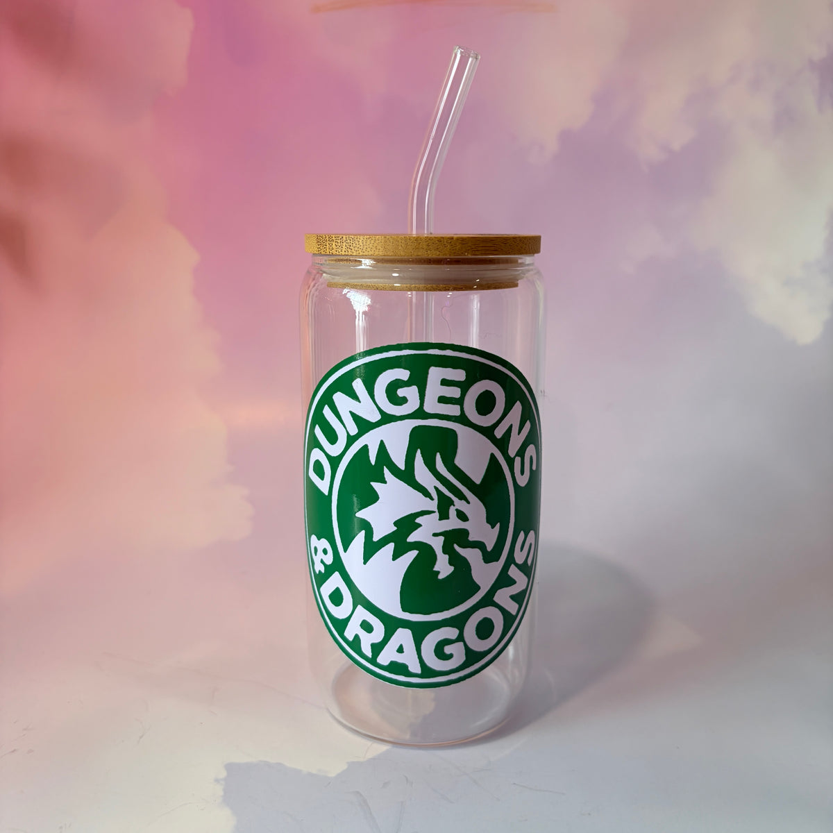 16 oz Dungeons and Dragons glass coffee can with vinyl fantasy design, bamboo lid engraved with two D20 dice, and straw. Custom colors available. Handwash only; not dishwasher or microwave safe.