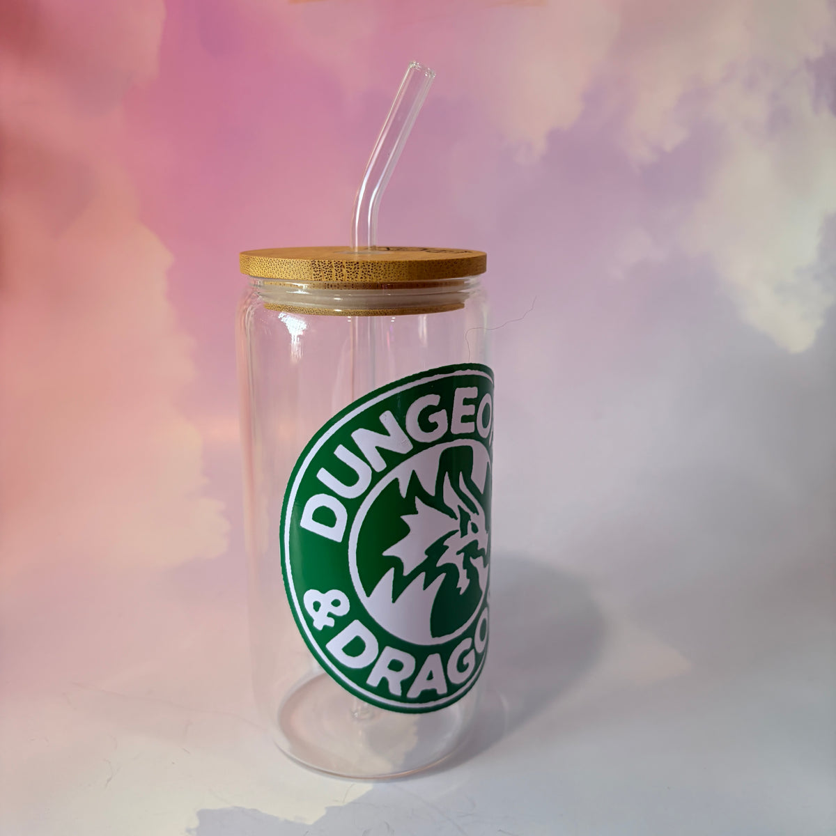 16 oz Dungeons and Dragons glass coffee can with vinyl fantasy design, bamboo lid engraved with two D20 dice, and straw. Custom colors available. Handwash only; not dishwasher or microwave safe.