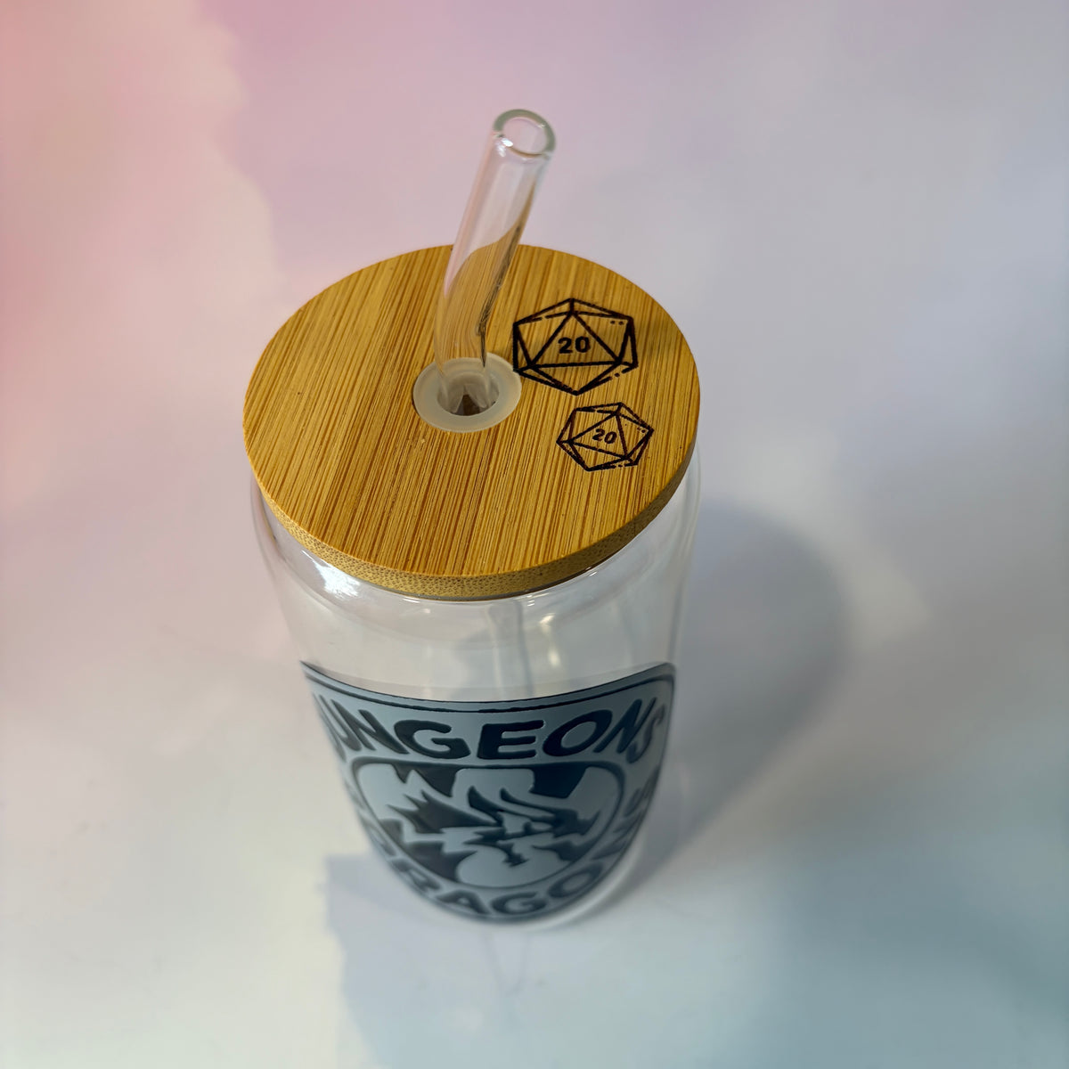 16 oz Dungeons and Dragons glass coffee can with vinyl fantasy design, bamboo lid engraved with two D20 dice, and straw. Custom colors available. Handwash only; not dishwasher or microwave safe.