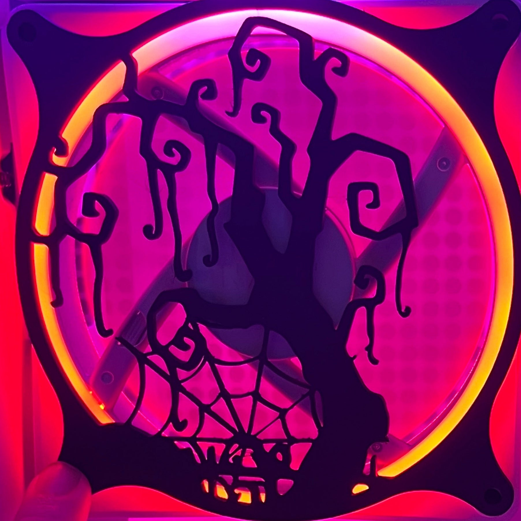 Decorative PC fan cover featuring a twisted tree and spider web design, ideal for adding a spooky touch to your gaming setup. Crafted from high-quality materials, this cover is compatible with standard 120mm fans. Featured on a rainbow LED fan.