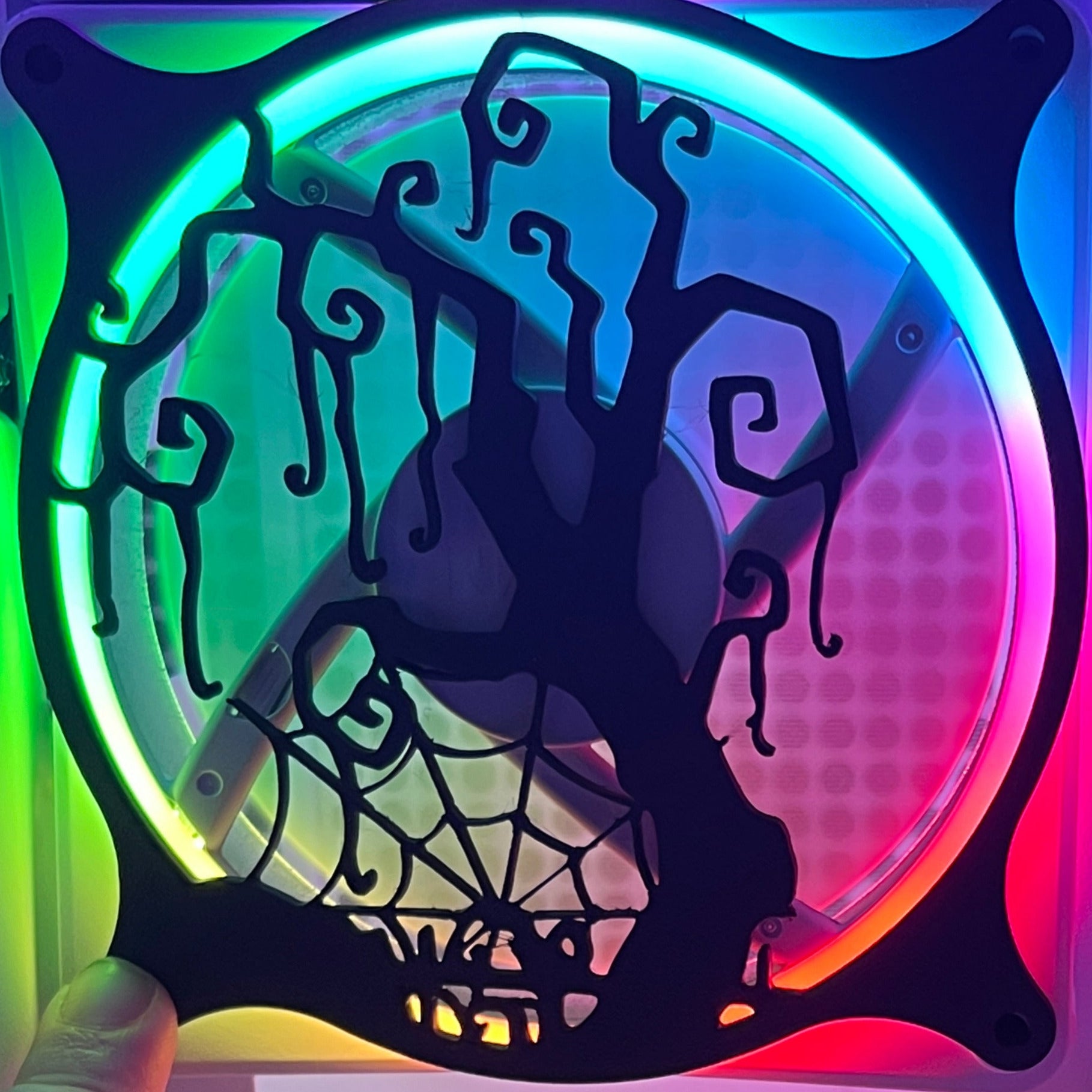 Decorative PC fan cover featuring a twisted tree and spider web design, ideal for adding a spooky touch to your gaming setup. Crafted from high-quality materials, this cover is compatible with standard 120mm fans. Featured on a rainbow LED fan.