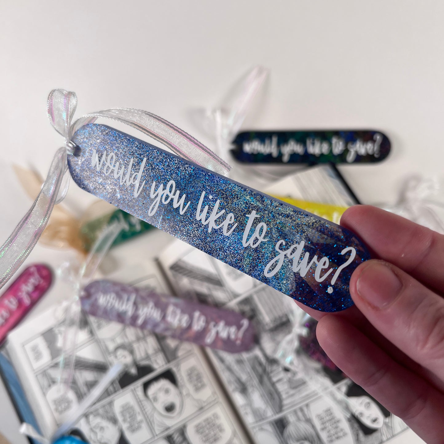 Handmade resin bookmark for gamers featuring 'Would you like to save?' design, vibrant colors, and glittery details. Perfect gift for RPG fans.