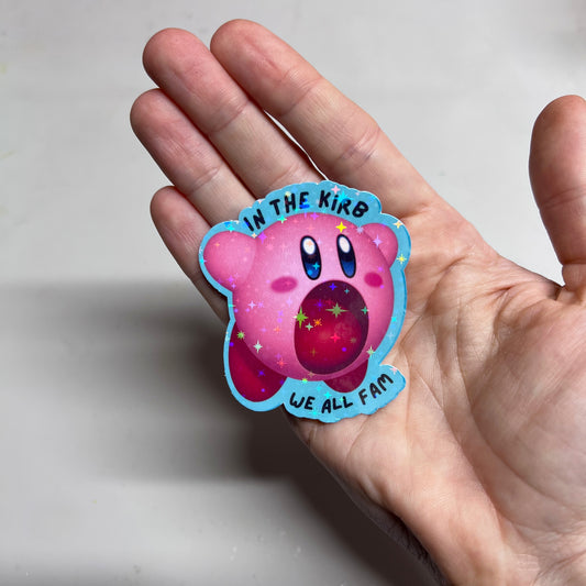 Holographic vinyl sticker featuring a cute Kirby with the phrase "In the Kirb, We All Fam." Perfect for laptops, water bottles, or gamer gear.