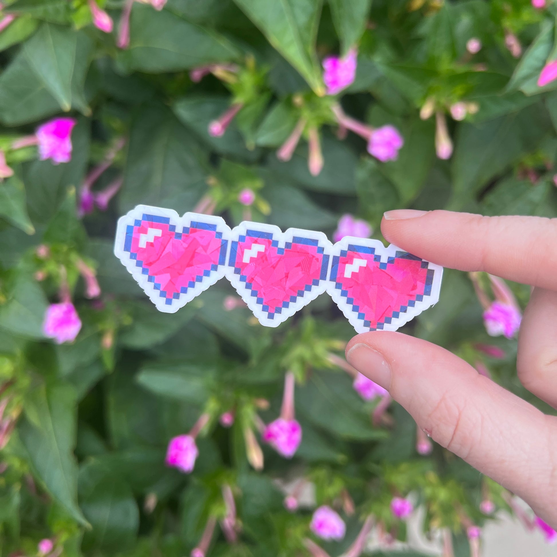 Holographic gamer heart sticker featuring 3 red pixel hearts in a heart container design. Perfect for laptops, water bottles, and game-themed journals.