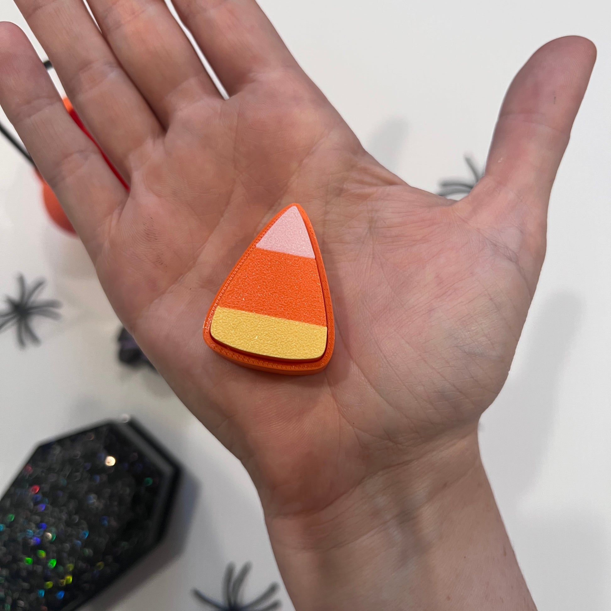 Cute Halloween clicker set with glow-in-the-dark ghost, candy corn, chocolate bat, and wrapped candy fidget toys in a festive pumpkin pail container.