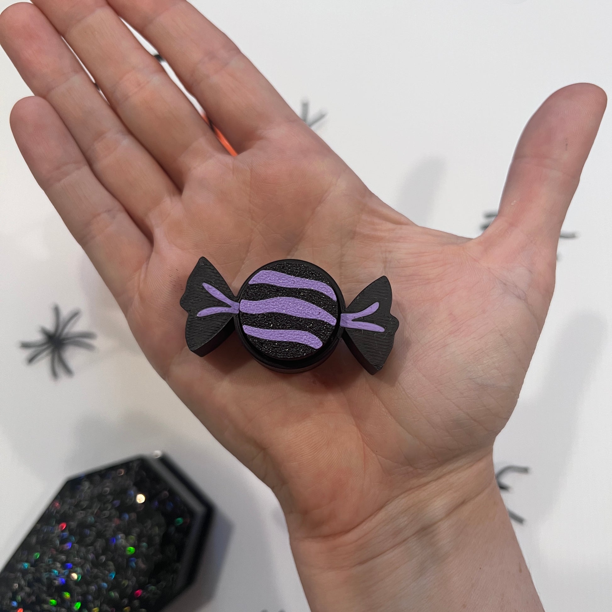 Cute Halloween clicker set with glow-in-the-dark ghost, candy corn, chocolate bat, and wrapped candy fidget toys in a festive pumpkin pail container.