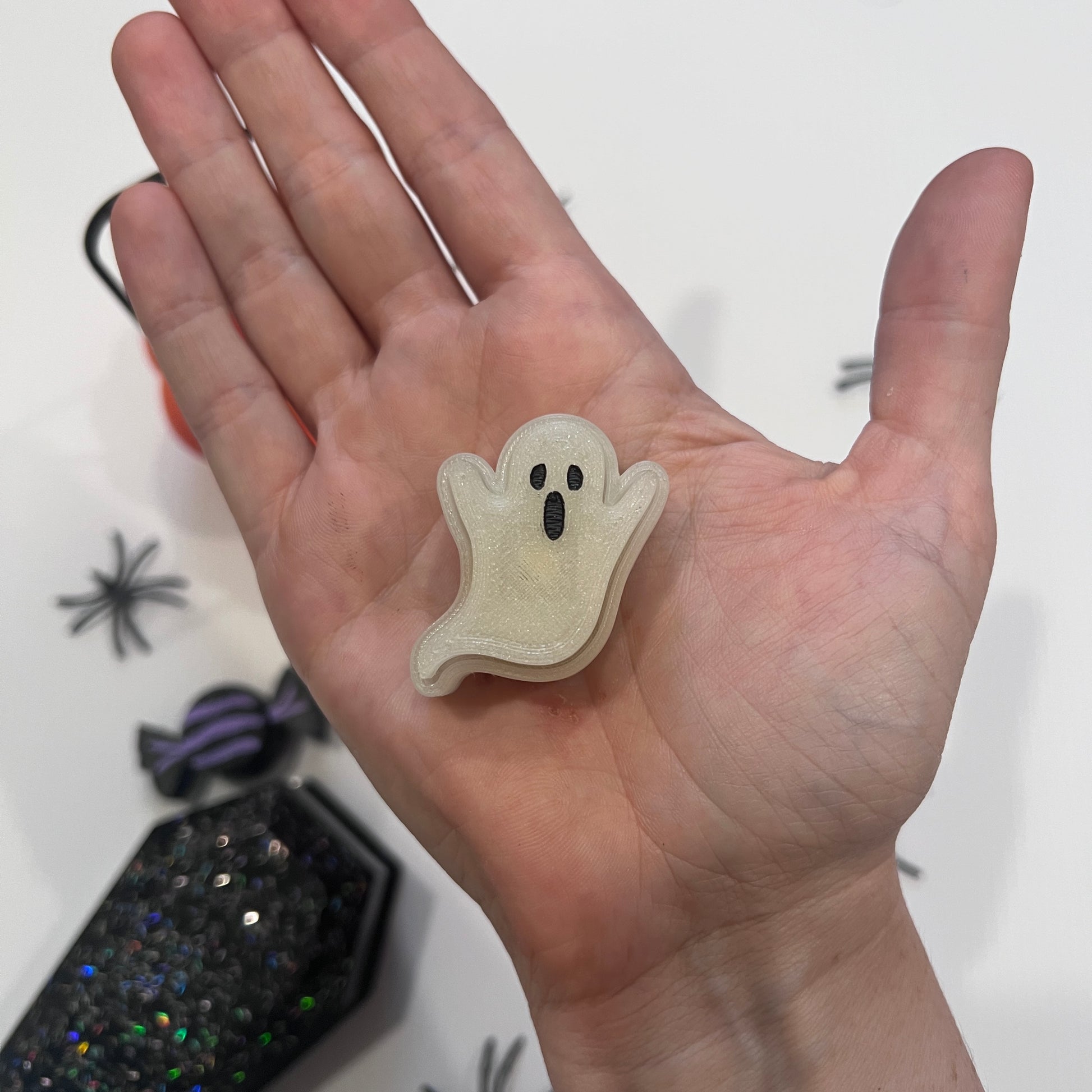 Cute Halloween clicker set with glow-in-the-dark ghost, candy corn, chocolate bat, and wrapped candy fidget toys in a festive pumpkin pail container.