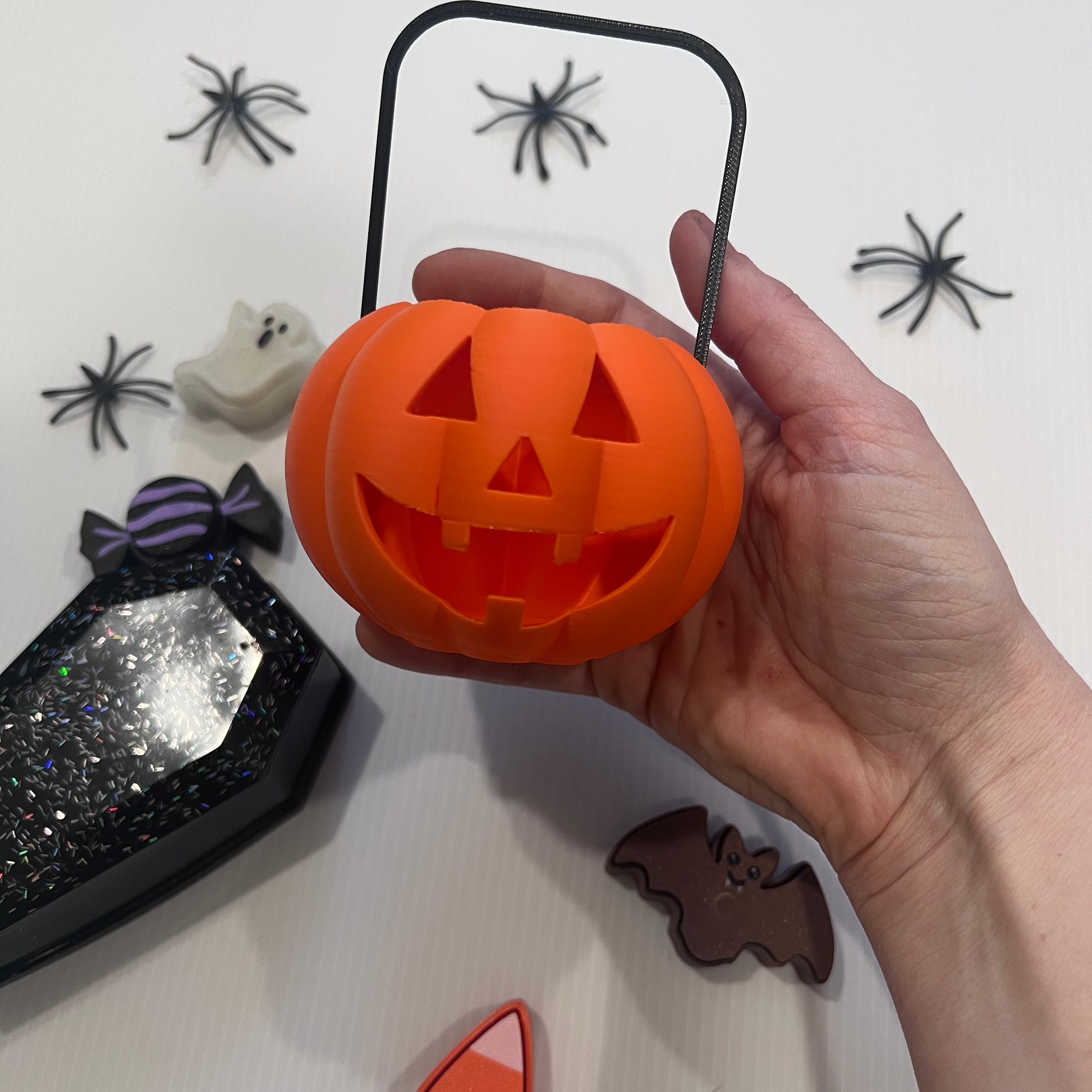Cute Halloween clicker set with glow-in-the-dark ghost, candy corn, chocolate bat, and wrapped candy fidget toys in a festive pumpkin pail container.