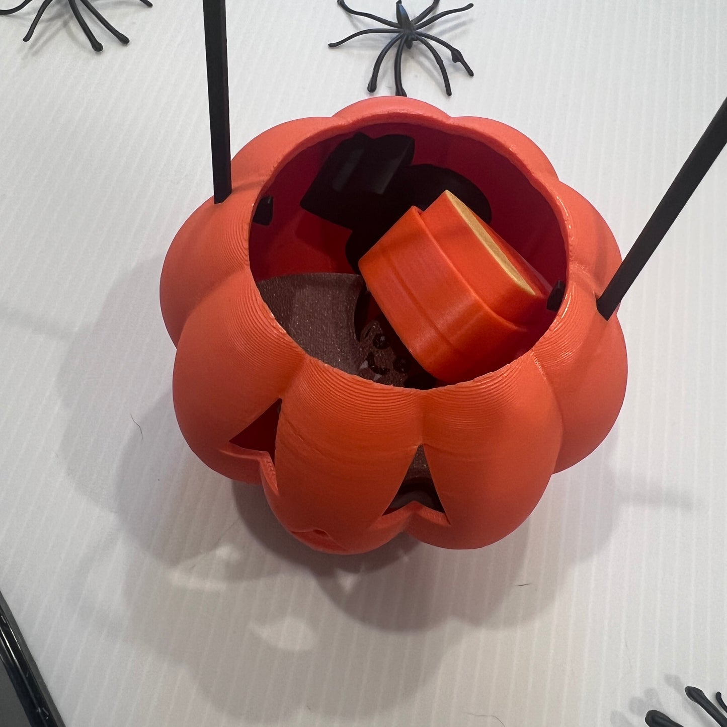 Cute Halloween clicker set with glow-in-the-dark ghost, candy corn, chocolate bat, and wrapped candy fidget toys in a festive pumpkin pail container.