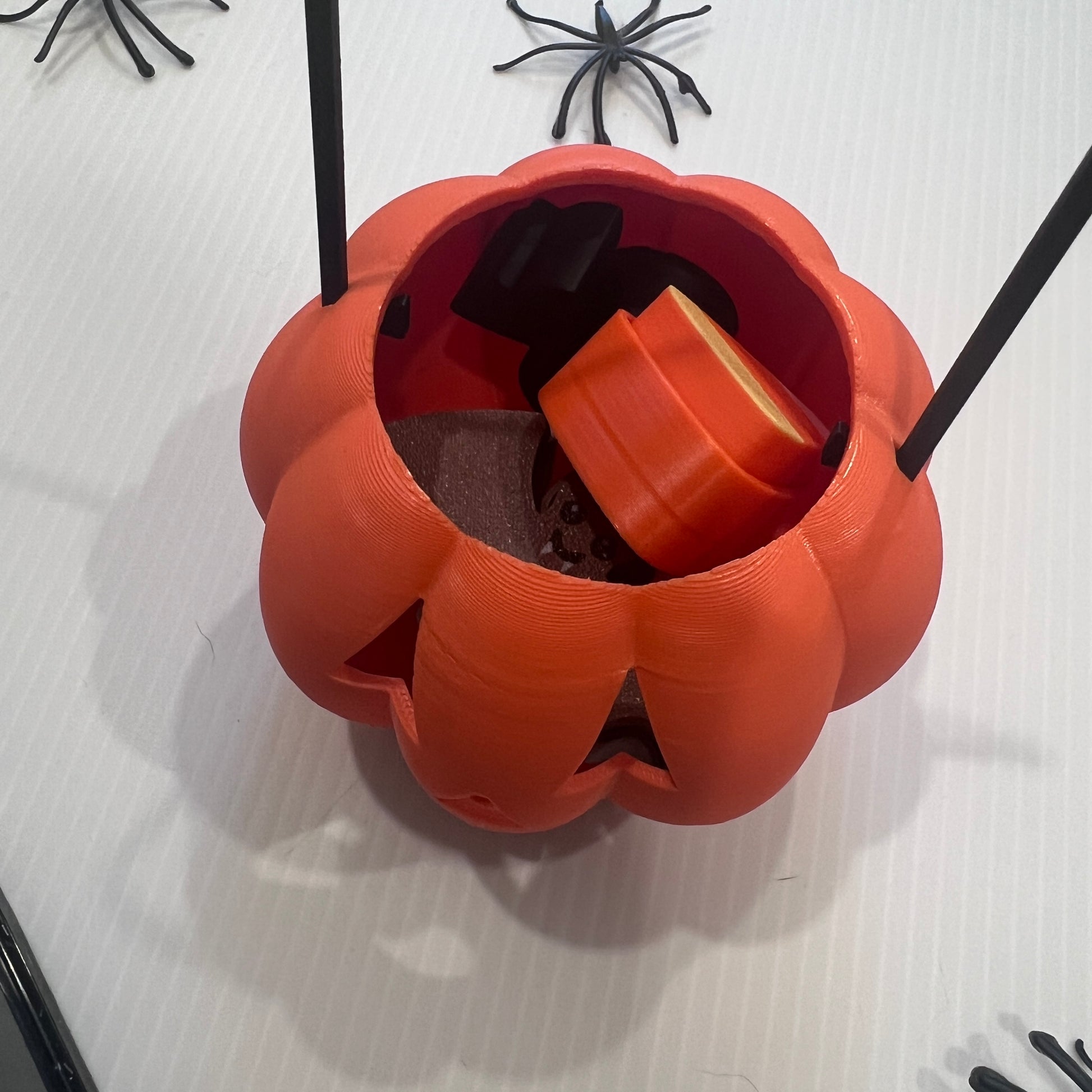 Cute Halloween clicker set with glow-in-the-dark ghost, candy corn, chocolate bat, and wrapped candy fidget toys in a festive pumpkin pail container.