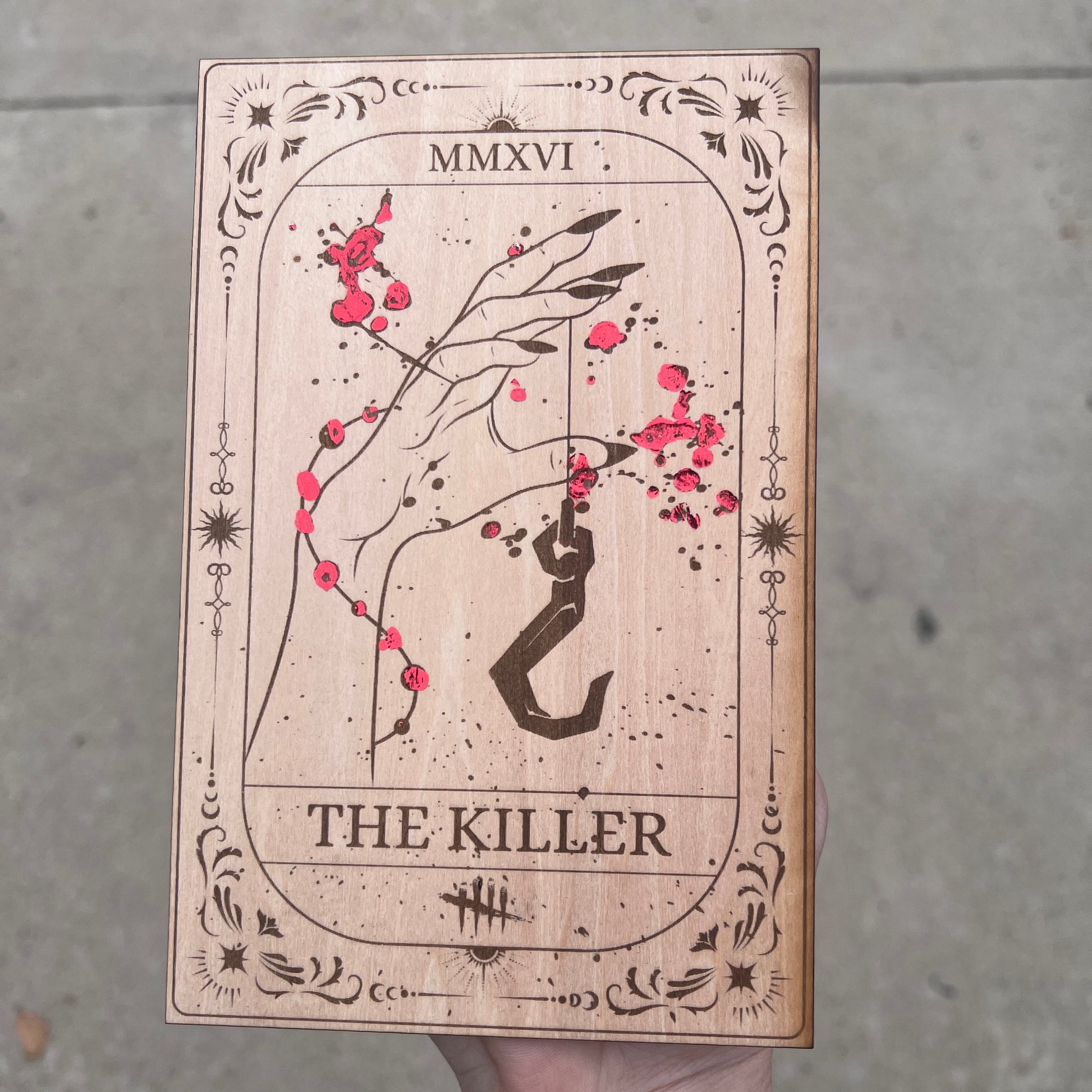Laser engraved wooden tarot card featuring “The Killer” inspired by Dead by Daylight with red foiled accents. Horror-themed gamer decor perfect for fans of spooky games and tarot.