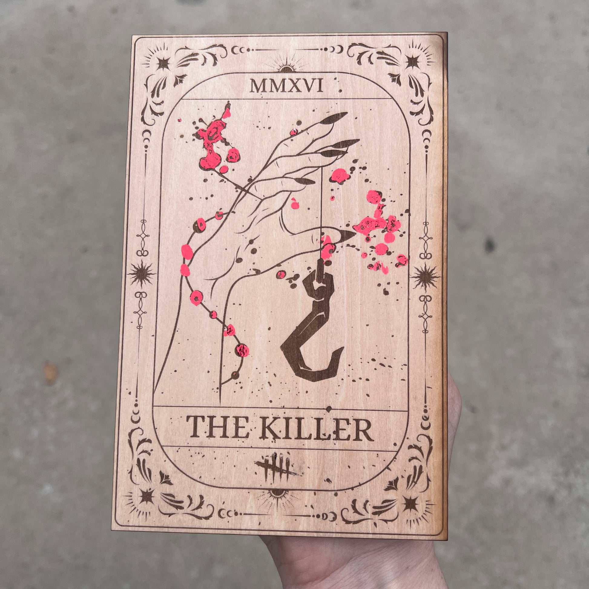 Laser engraved wooden tarot card featuring “The Killer” inspired by Dead by Daylight with red foiled accents. Horror-themed gamer decor perfect for fans of spooky games and tarot.