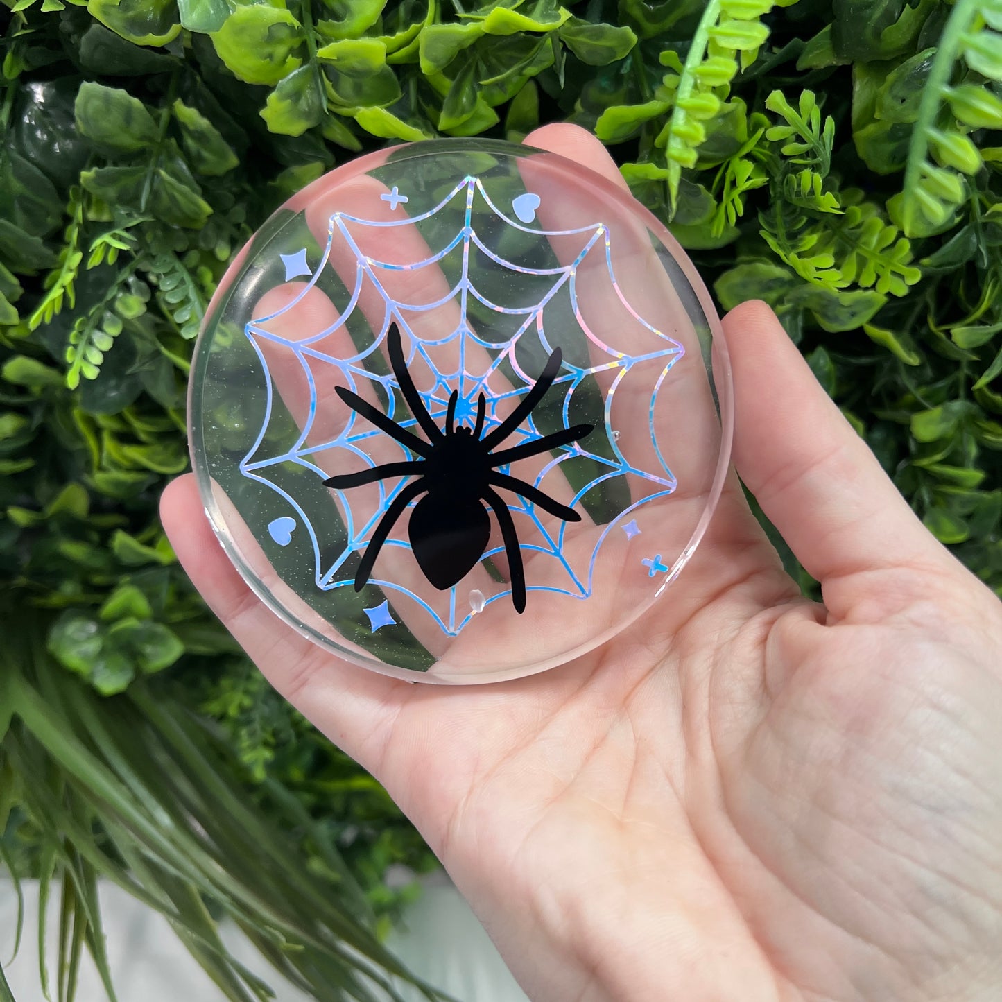 Pastel goth spiderweb coasters featuring a handmade resin design with intricate spiderwebs. Perfect for adding a dark, spooky aesthetic to any home. These unique coasters blend pastel colors with a goth twist, great for goth or Halloween-themed decor