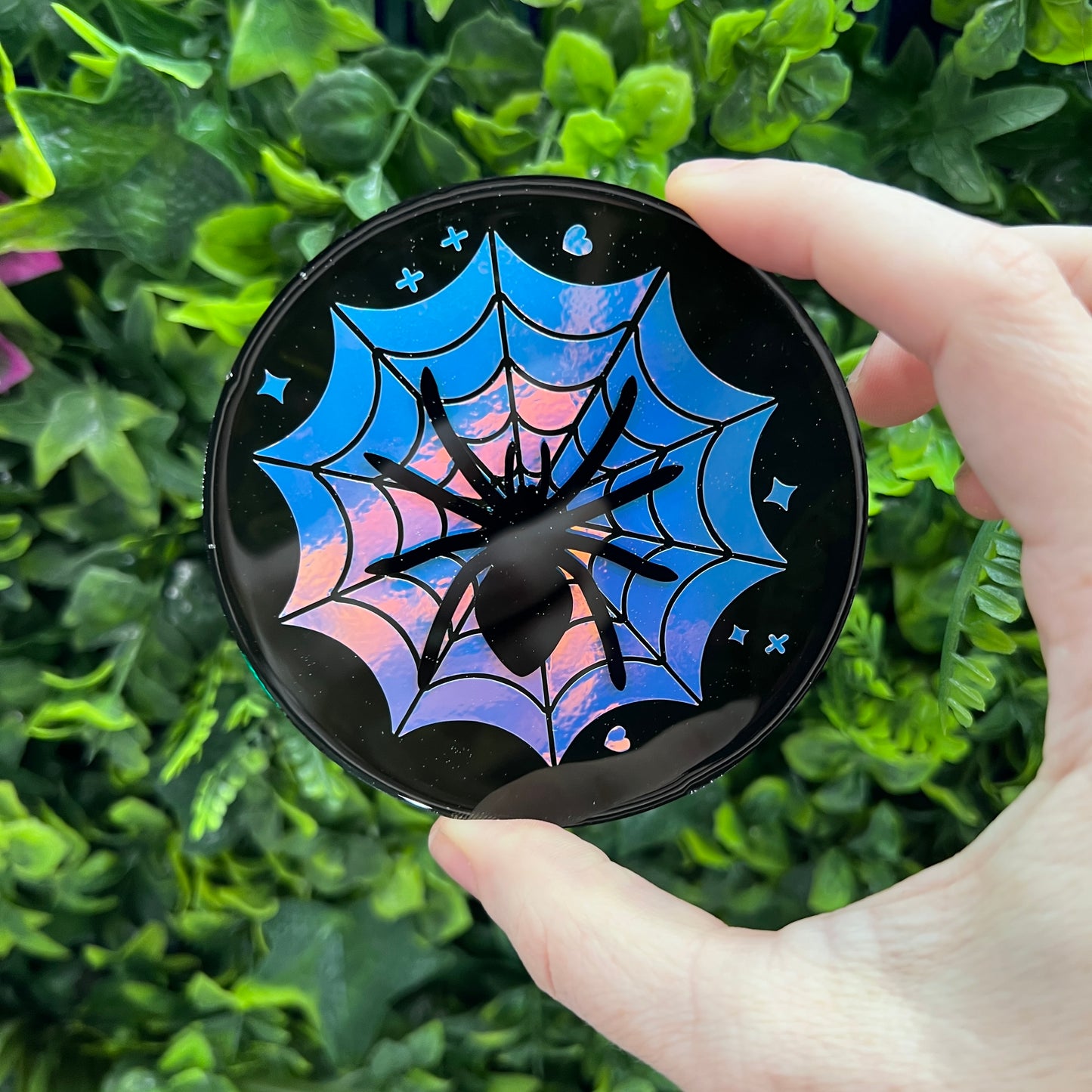 Pastel goth spiderweb coasters featuring a handmade resin design with intricate spiderwebs. Perfect for adding a dark, spooky aesthetic to any home. These unique coasters blend pastel colors with a goth twist, great for goth or Halloween-themed decor