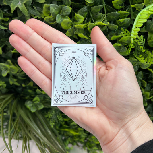 Silver Holographic Sims tarot card sticker featuring "The Simmer" with a radiant plumbob design. A must-have for Sims fans, gamers, and lovers of geeky decor.