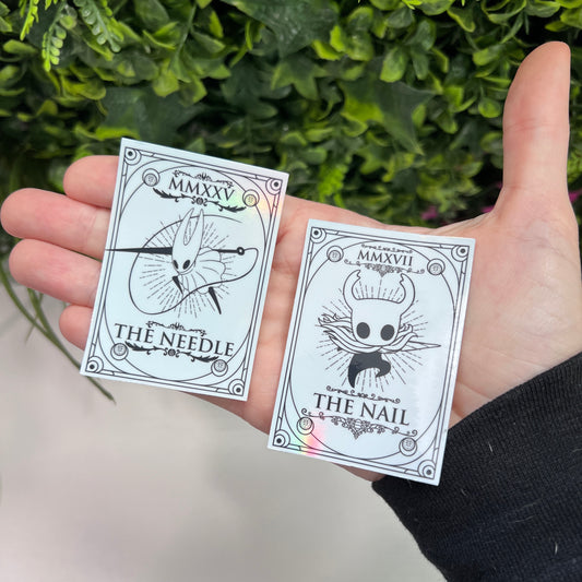 Silver Holographic tarot card stickers featuring Hollow Knight as The Nail and Hornet as the Needle. Unique indie game fan art collectible.