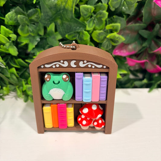 4-key bookcase fidget clicker keychain with books, frog, and mushroom.
