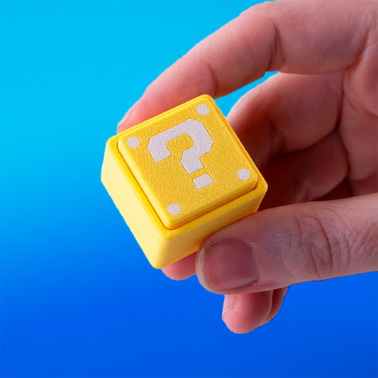 Super Mario-inspired question block fidget clicker, perfect for gamers. Handheld stress relief toy with satisfying click action. Ideal gift for Nintendo fans and retro gaming lovers.