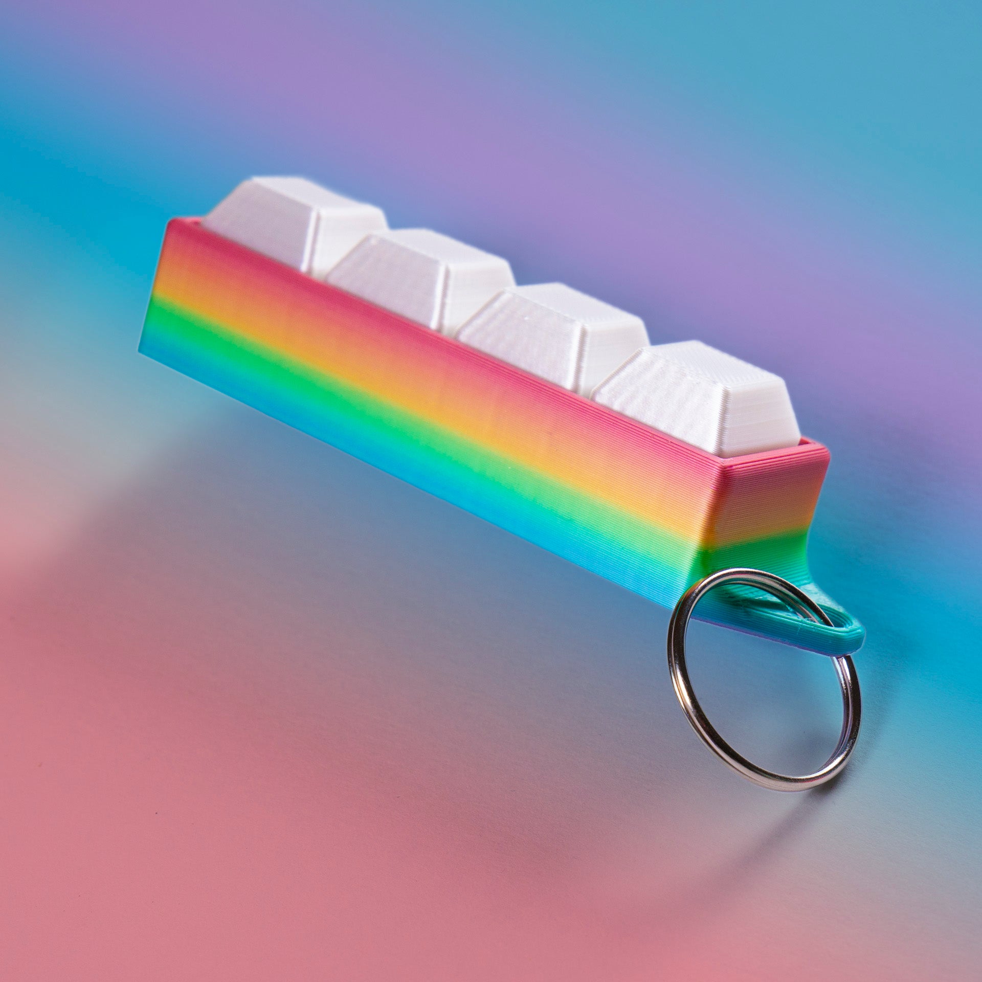 Rainbow 4-key mechanical clicker with white keycaps and keychain loop, perfect for fidgeting, gamer desk setups, or stress relief on the go.