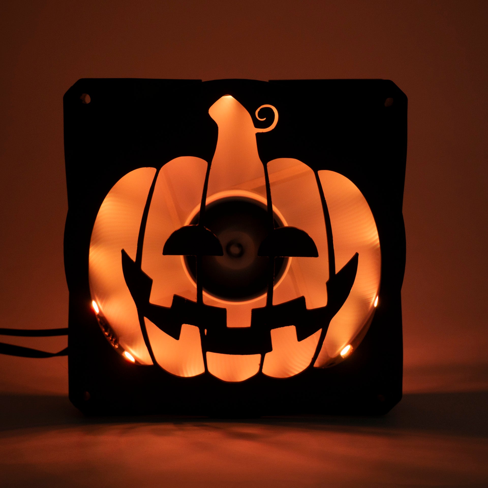 3D printed PC fan grill shaped like a spooky jack-o'-lantern pumpkin. Perfect Halloween-themed case mod for gamers and tech lovers.