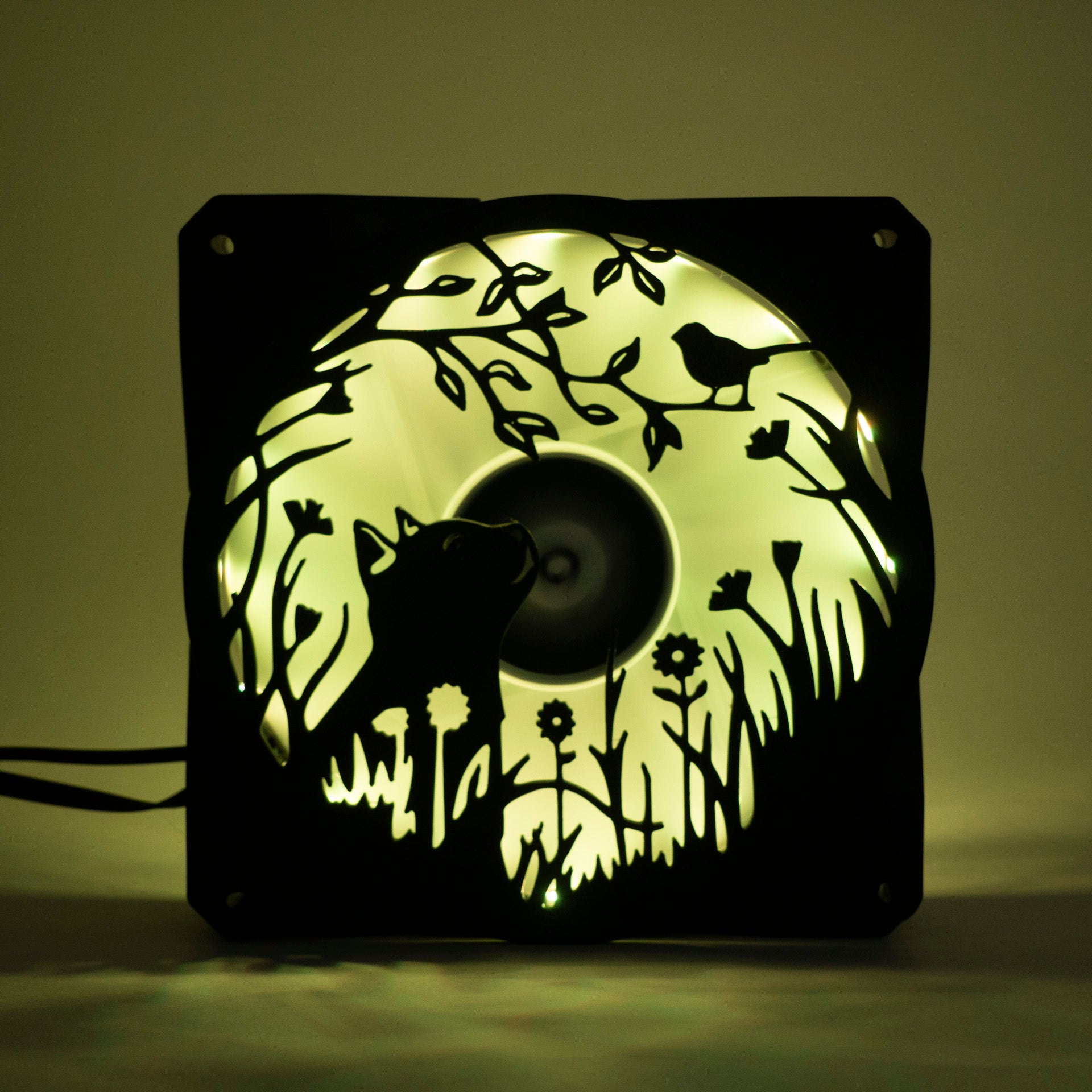 Adorable 3D printed PC fan grill featuring a cat and bird in a garden scene. Adds cozy charm and personality to any gaming or desktop setup.