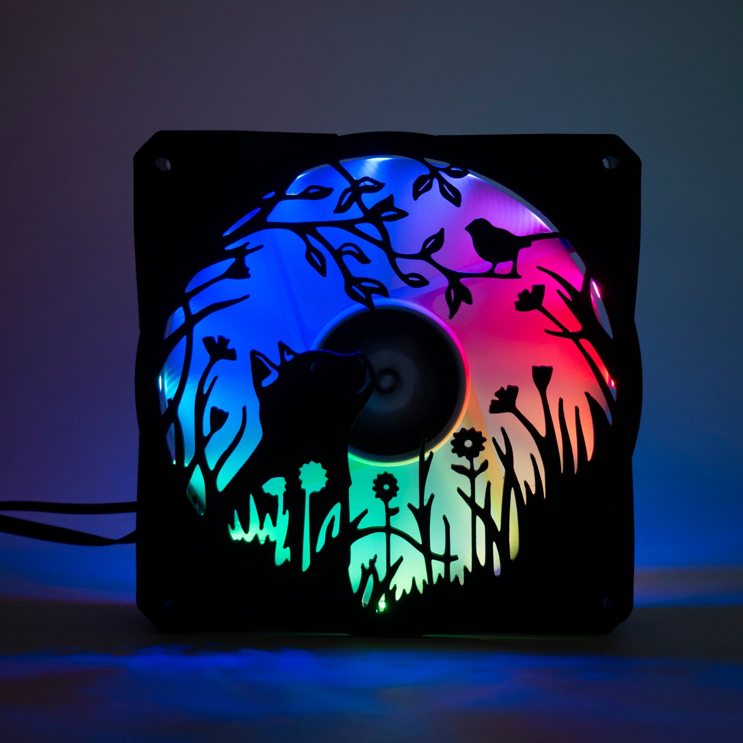 Adorable 3D printed PC fan grill featuring a cat and bird in a garden scene. Adds cozy charm and personality to any gaming or desktop setup.