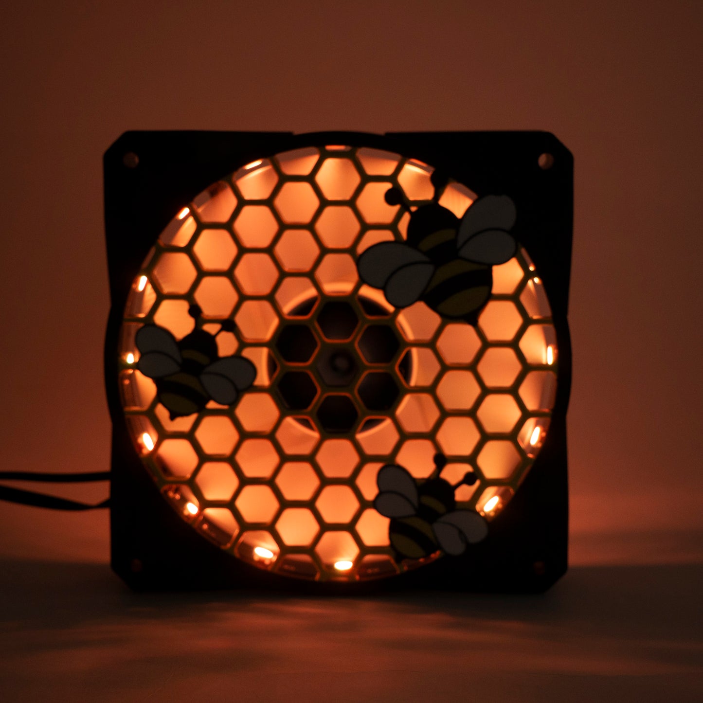 Adorable 3D printed PC fan grill featuring bees and honeycomb. Perfect for customizing aesthetic gamer setups with a cute, nature-inspired design.