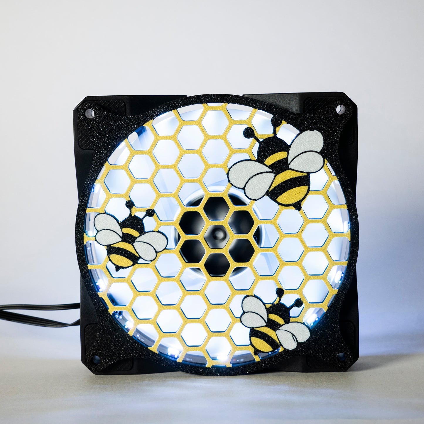 Adorable 3D printed PC fan grill featuring bees and honeycomb. Perfect for customizing aesthetic gamer setups with a cute, nature-inspired design.