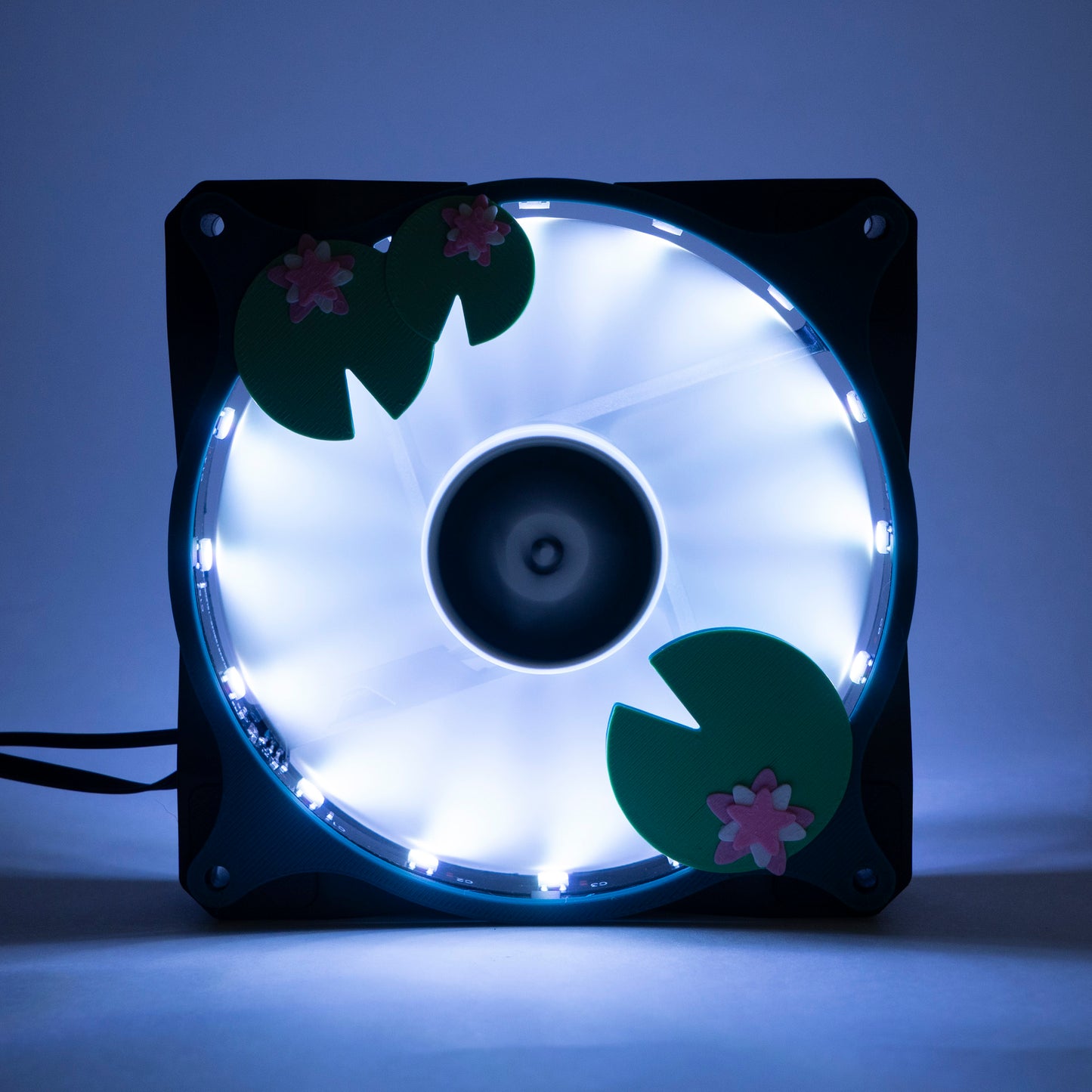 Adorable 3D printed PC fan grill with lily pad and lotus flower design. A cute nature-inspired fan cover perfect for cozy, aesthetic gaming setups.