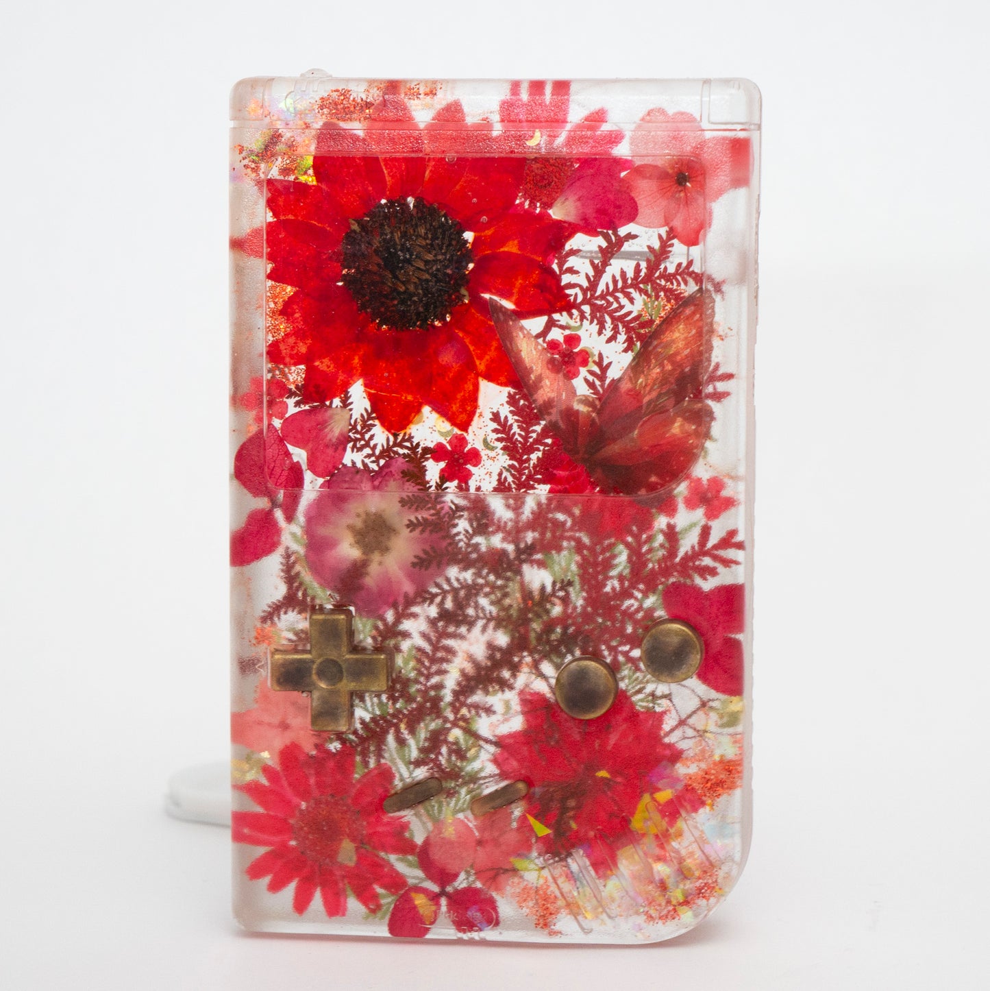 Customizable resin Gameboy with pressed flowers and glitter embedded in clear resin. Perfect for collectors and gaming fans alike.