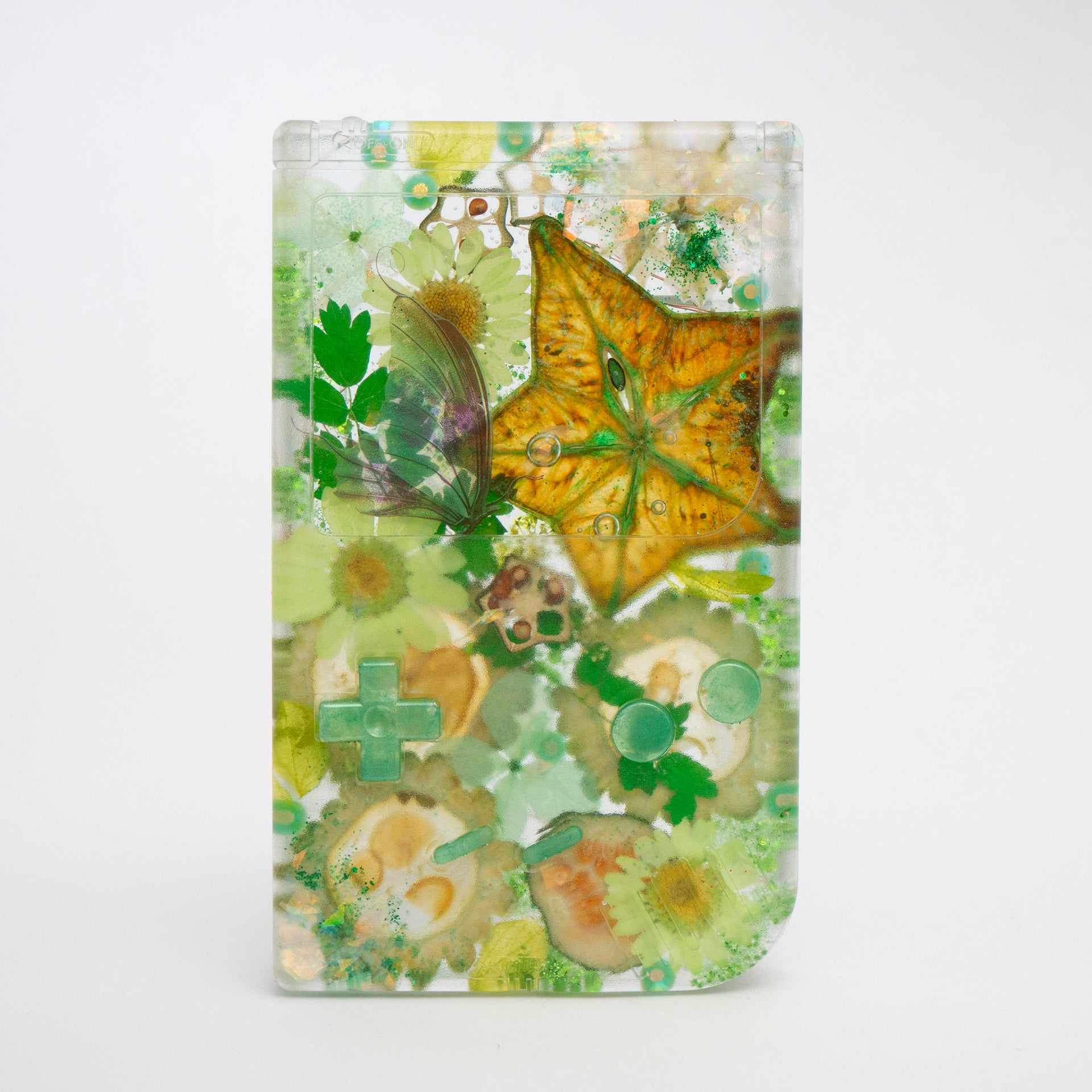 Customizable resin Gameboy with pressed flowers and glitter embedded in clear resin. Perfect for collectors and gaming fans alike.
