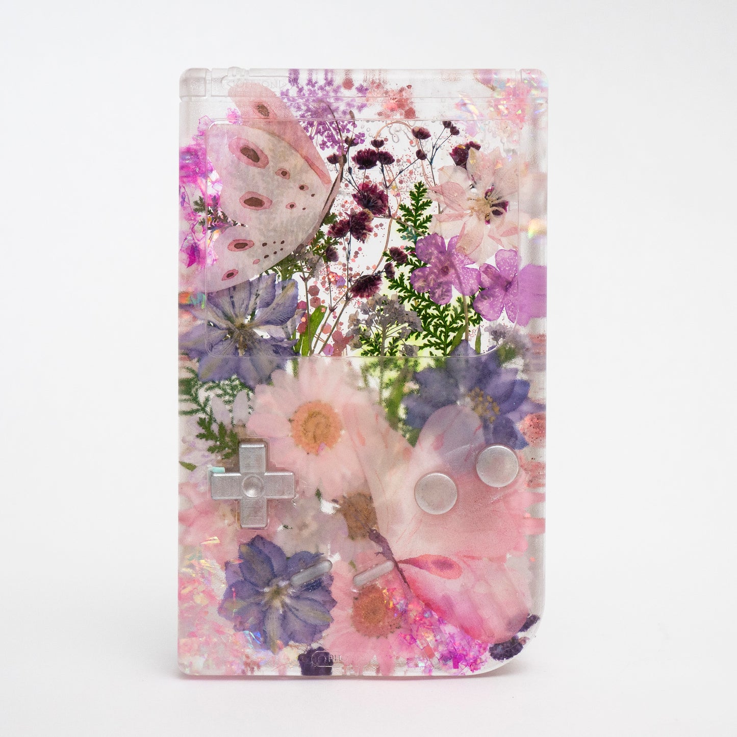 Customizable resin Gameboy with pressed flowers and glitter embedded in clear resin. Perfect for collectors and gaming fans alike.