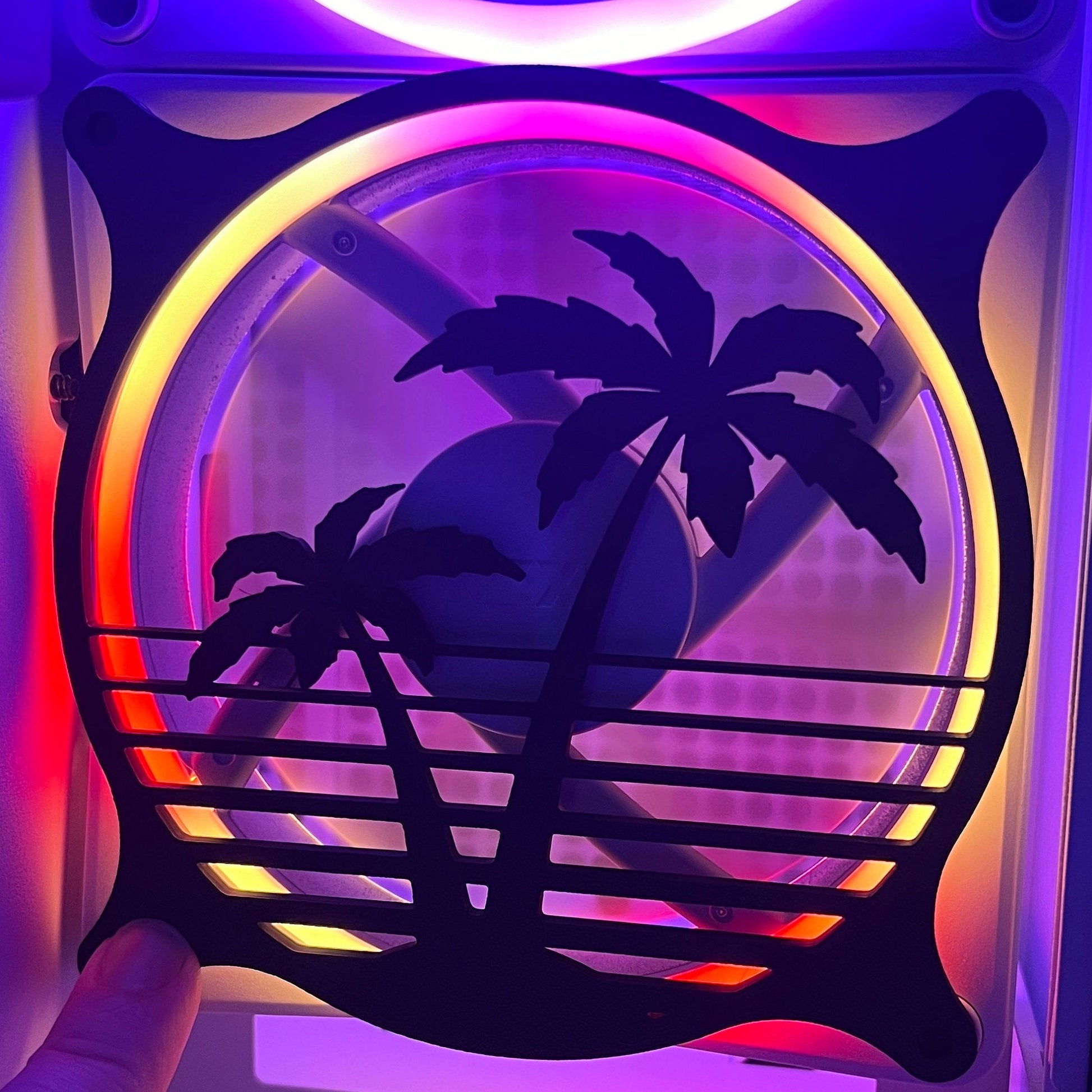 Decorative PC fan cover featuring an 80s tropical palm tree design with a black textured finish. Perfect for adding a unique and stylish touch to gaming or custom PC builds, blending functionality with aesthetic flair.