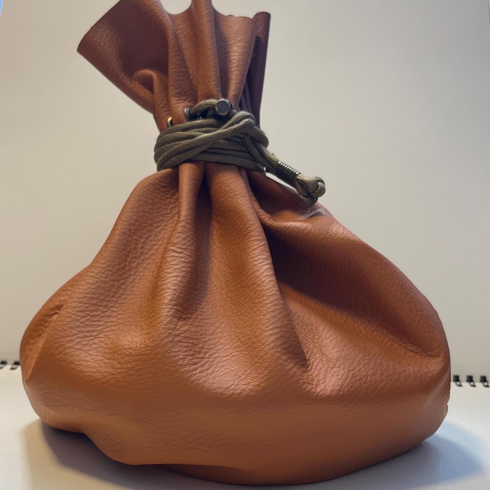 Handcrafted leather dice bag with drawstring, ideal for storing RPG dice sets. Perfect for DnD, tabletop games, or as a fantasy gift for gamers.