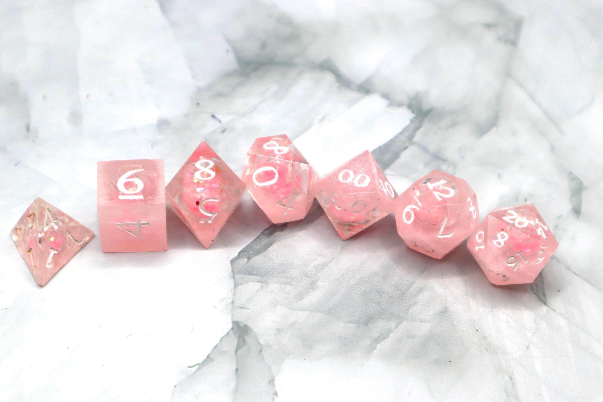 Handmade pink and white glitter liquid core resin dice set with shimmer effect, perfect for DnD, TTRPG players, and fantasy-themed gaming sessions.