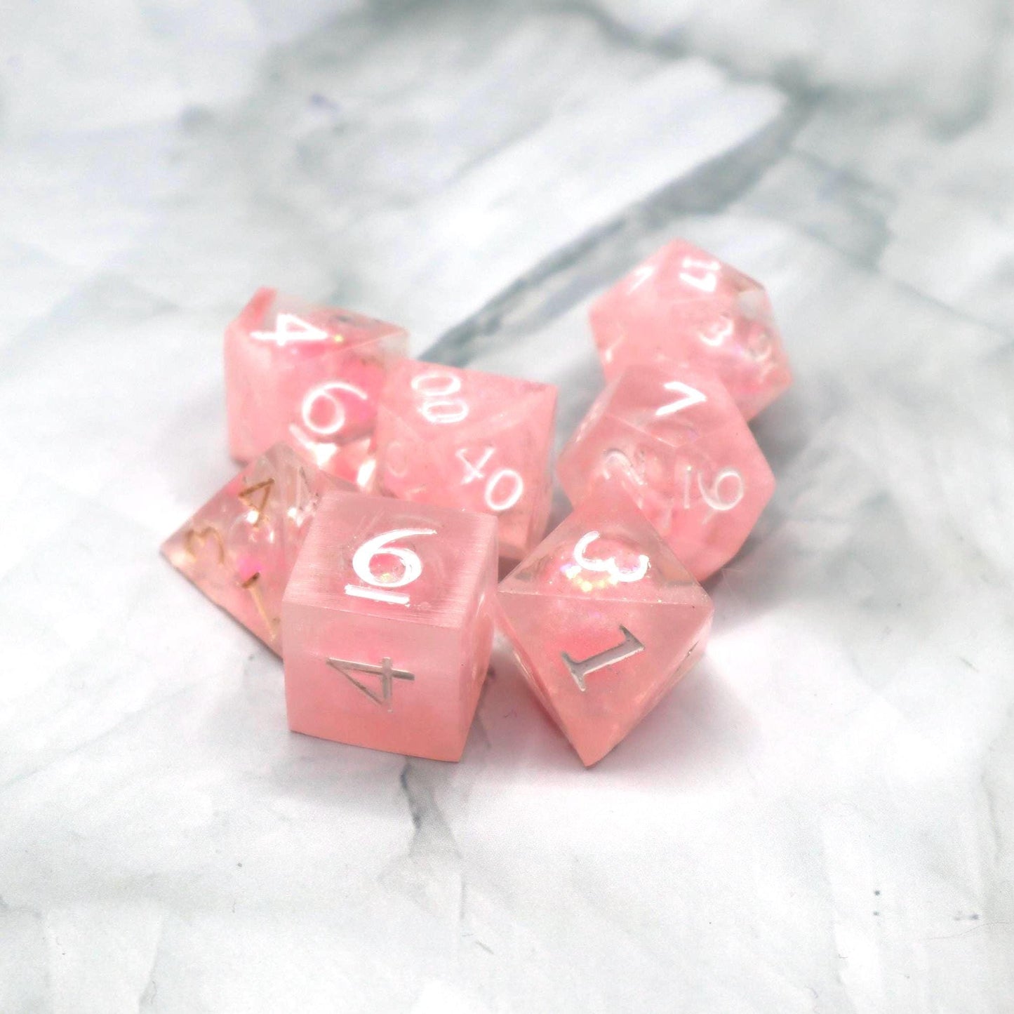 Handmade pink and white glitter liquid core resin dice set with shimmer effect, perfect for DnD, TTRPG players, and fantasy-themed gaming sessions.