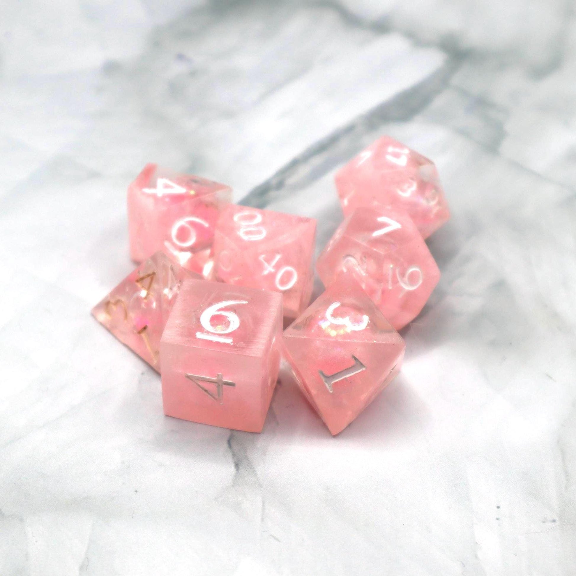 Handmade pink and white glitter liquid core resin dice set with shimmer effect, perfect for DnD, TTRPG players, and fantasy-themed gaming sessions.