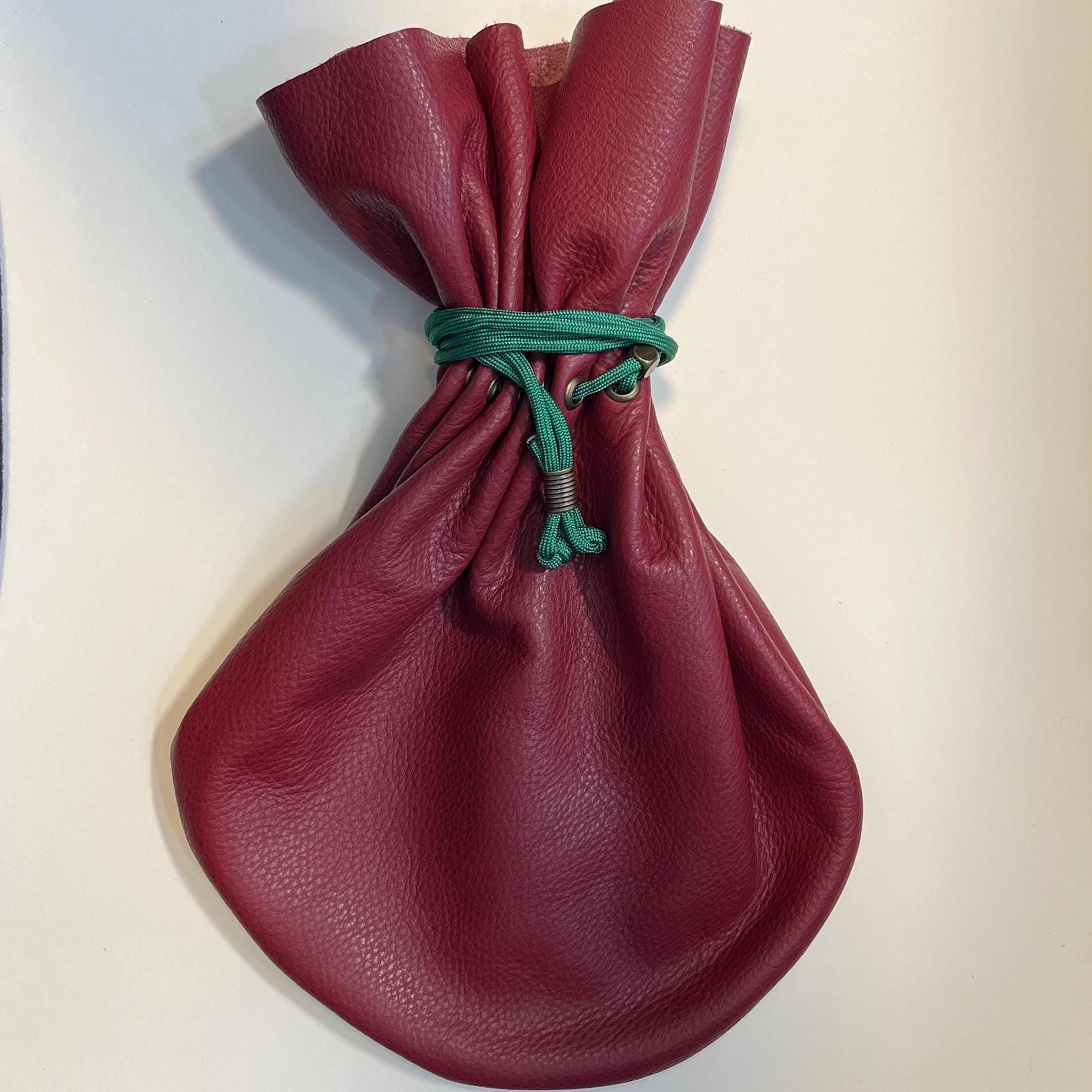 Handcrafted leather dice bag with drawstring, ideal for storing RPG dice sets. Perfect for DnD, tabletop games, or as a fantasy gift for gamers.