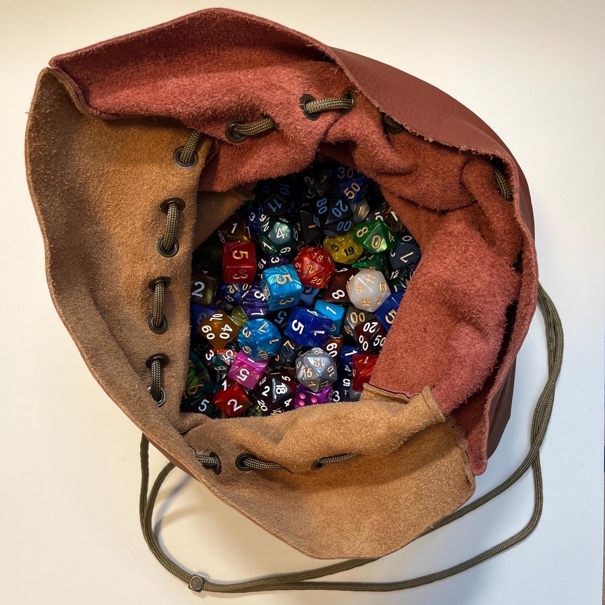 Handcrafted leather dice bag with drawstring, ideal for storing RPG dice sets. Perfect for DnD, tabletop games, or as a fantasy gift for gamers.