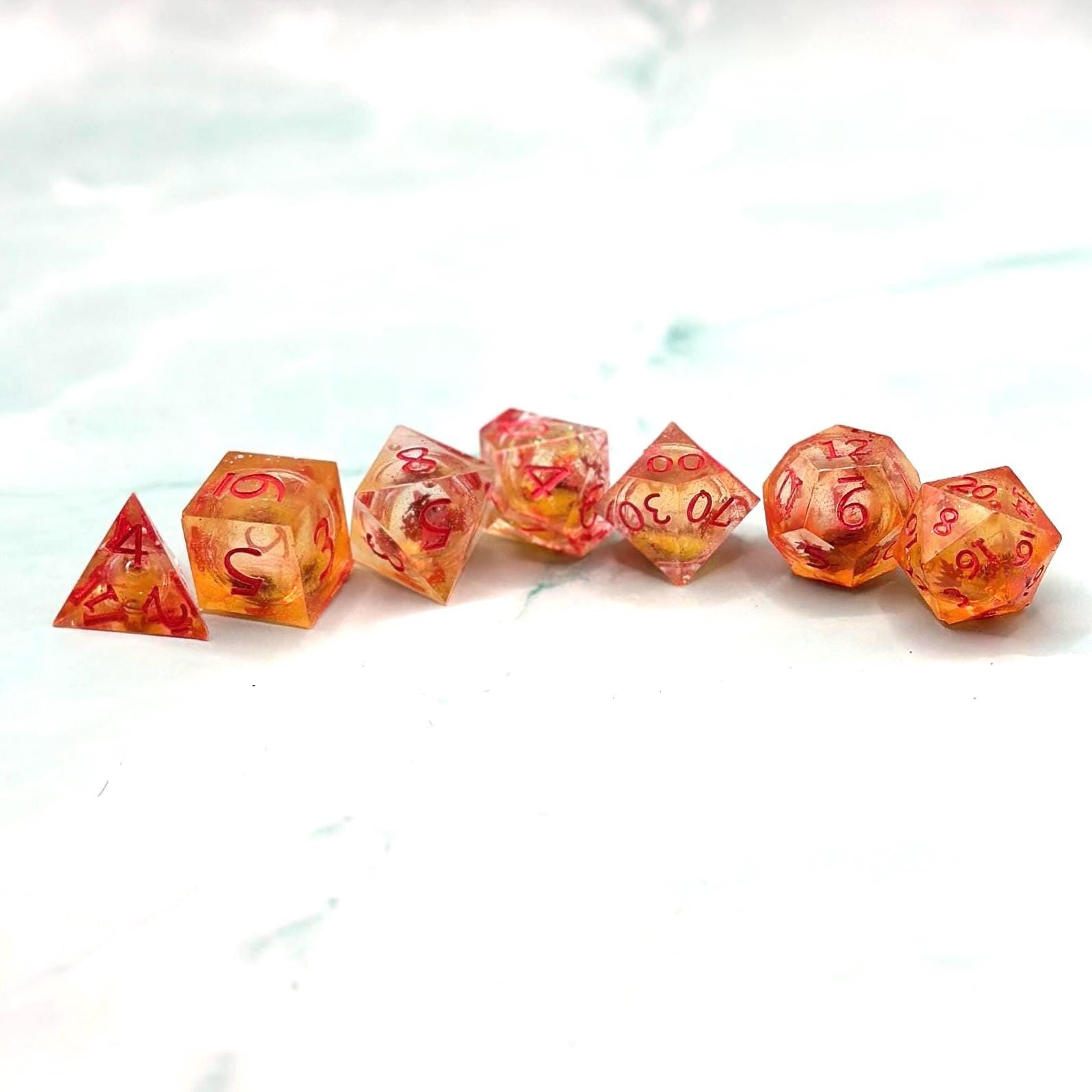 Orange Fall Foliage Liquid Core Dice Set – sharp edge polyhedral DnD dice featuring swirling autumn leaves and shimmering orange liquid core. Perfect for tabletop RPGs, Dungeons & Dragons, or dice collectors. Handmade resin dice with crisp numbers, glowing fall colors, and mesmerizing motion that captures the beauty of autumn. Ideal DnD gift or gaming accessory for players who love seasonal fantasy aesthetics.