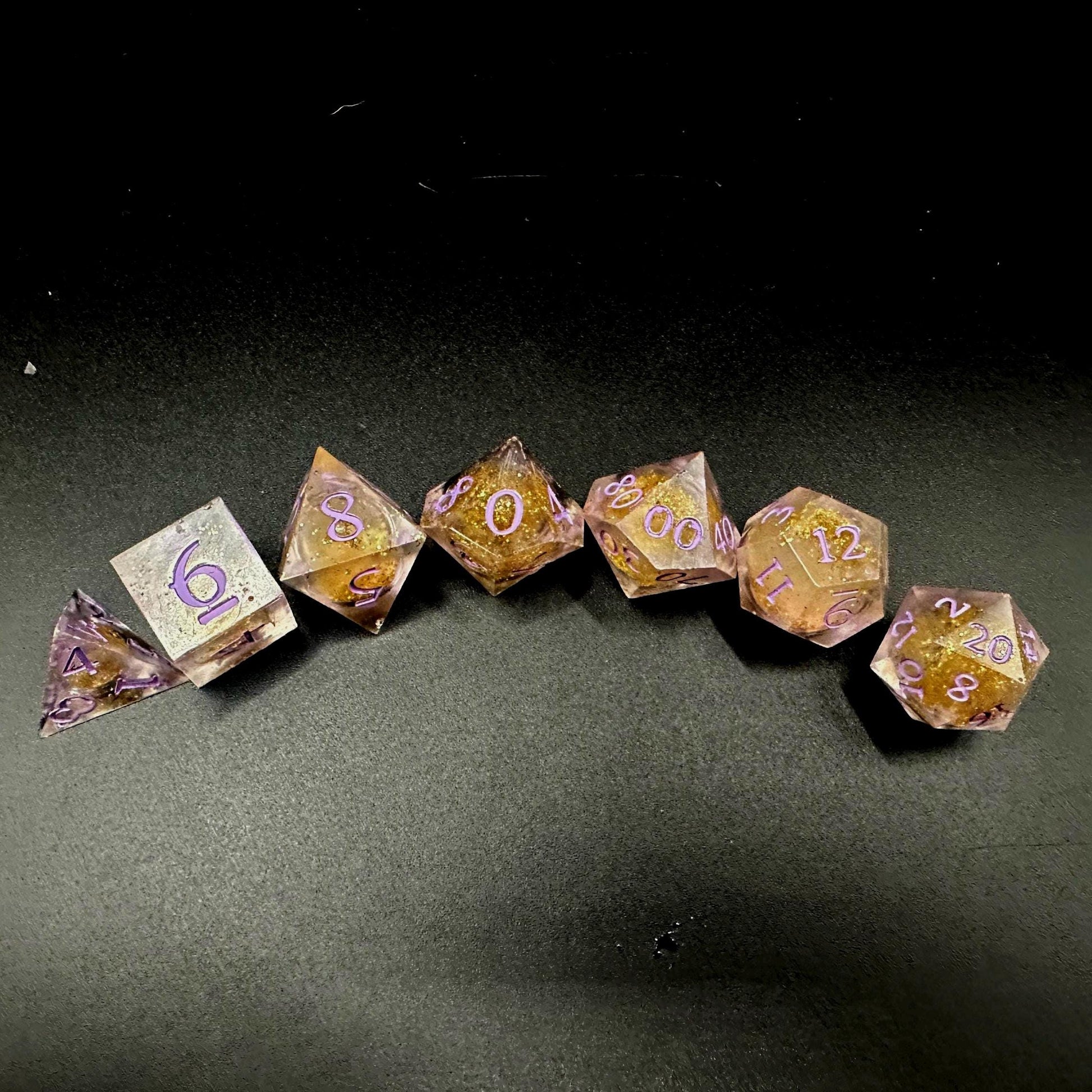 Light purple, pink, and gold glitter liquid core dice set shimmering with swirling metallic sparkle. Handcrafted polyhedral resin dice filled with floating glitter and vibrant liquid core for mesmerizing movement. Perfect for Dungeons & Dragons, tabletop RPGs, and dice collectors. Elegant pastel tones with gold accents add a magical, fantasy-inspired aesthetic for gaming sessions or gift giving.