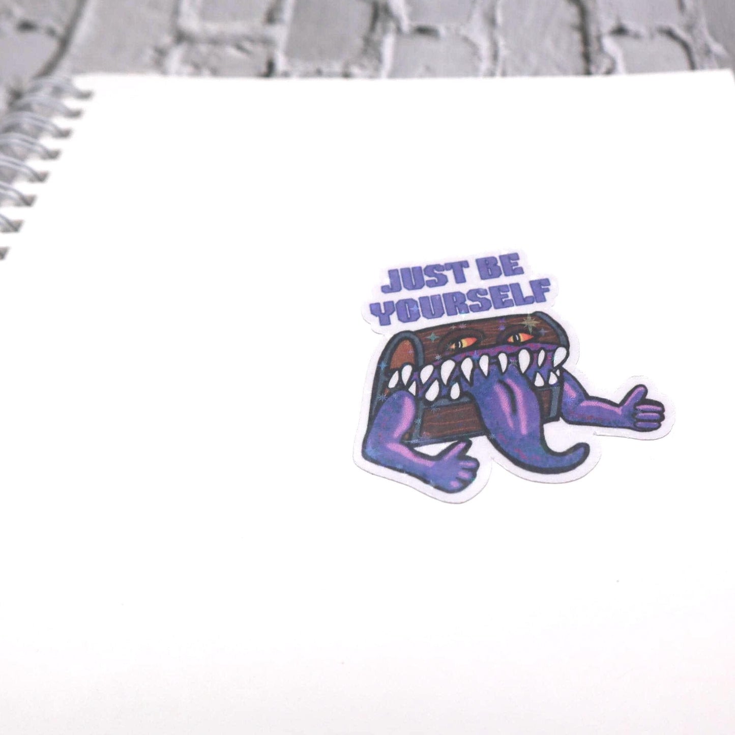 Holographic DnD mimic sticker with a grinning treasure chest and the phrase Just Be Yourself, perfect for laptops, water bottles, and tabletop RPG fans.