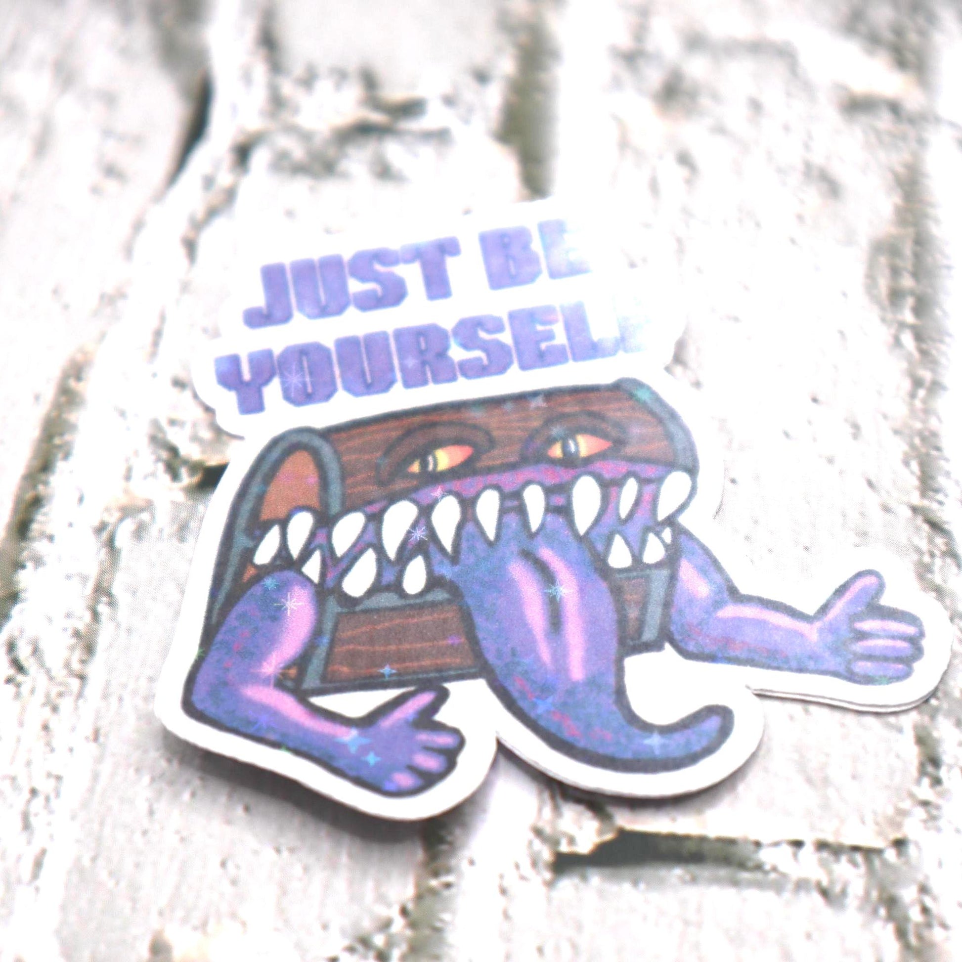 Holographic DnD mimic sticker with a grinning treasure chest and the phrase Just Be Yourself, perfect for laptops, water bottles, and tabletop RPG fans.