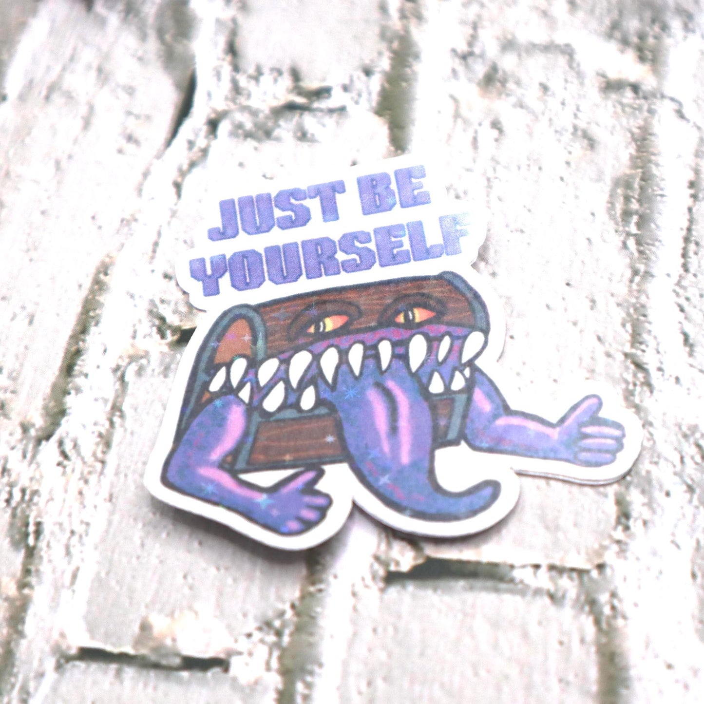 Holographic DnD mimic sticker with a grinning treasure chest and the phrase Just Be Yourself, perfect for laptops, water bottles, and tabletop RPG fans.
