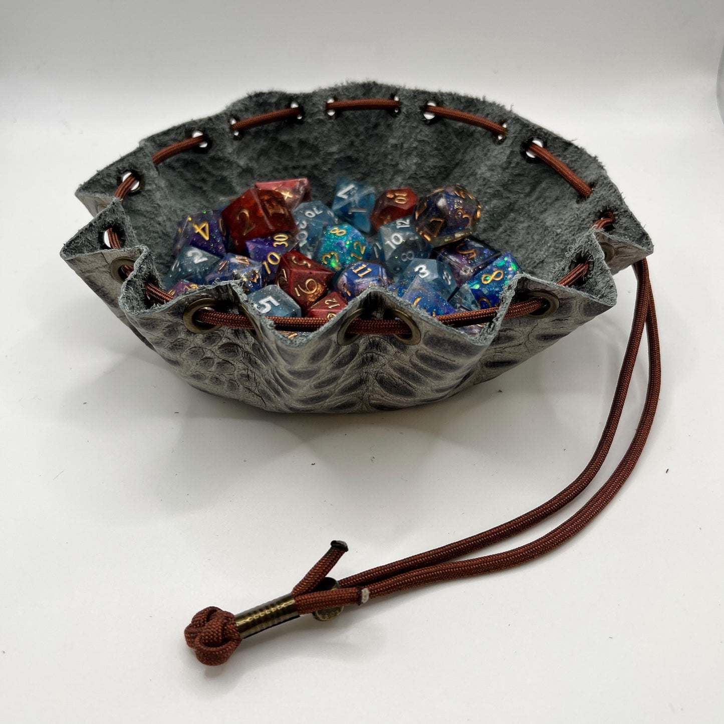 Handcrafted leather dice bag with drawstring, ideal for storing RPG dice sets. Perfect for DnD, tabletop games, or as a fantasy gift for gamers.