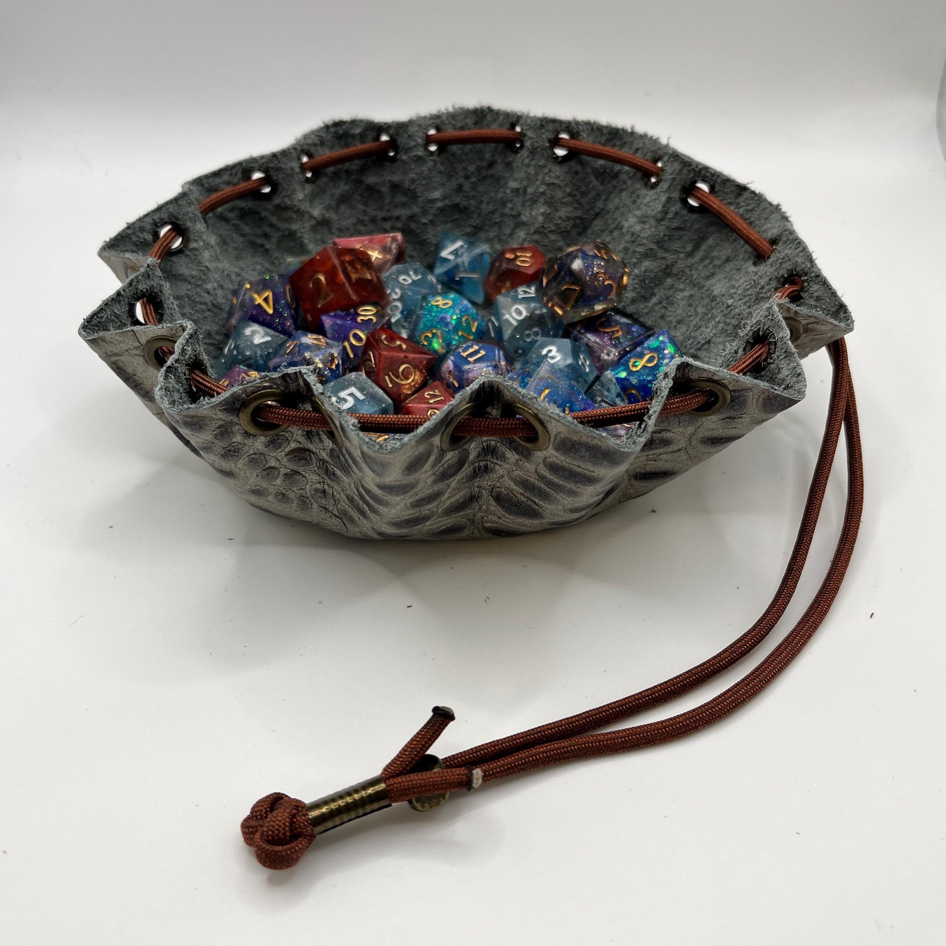 Handcrafted leather dice bag with drawstring, ideal for storing RPG dice sets. Perfect for DnD, tabletop games, or as a fantasy gift for gamers.