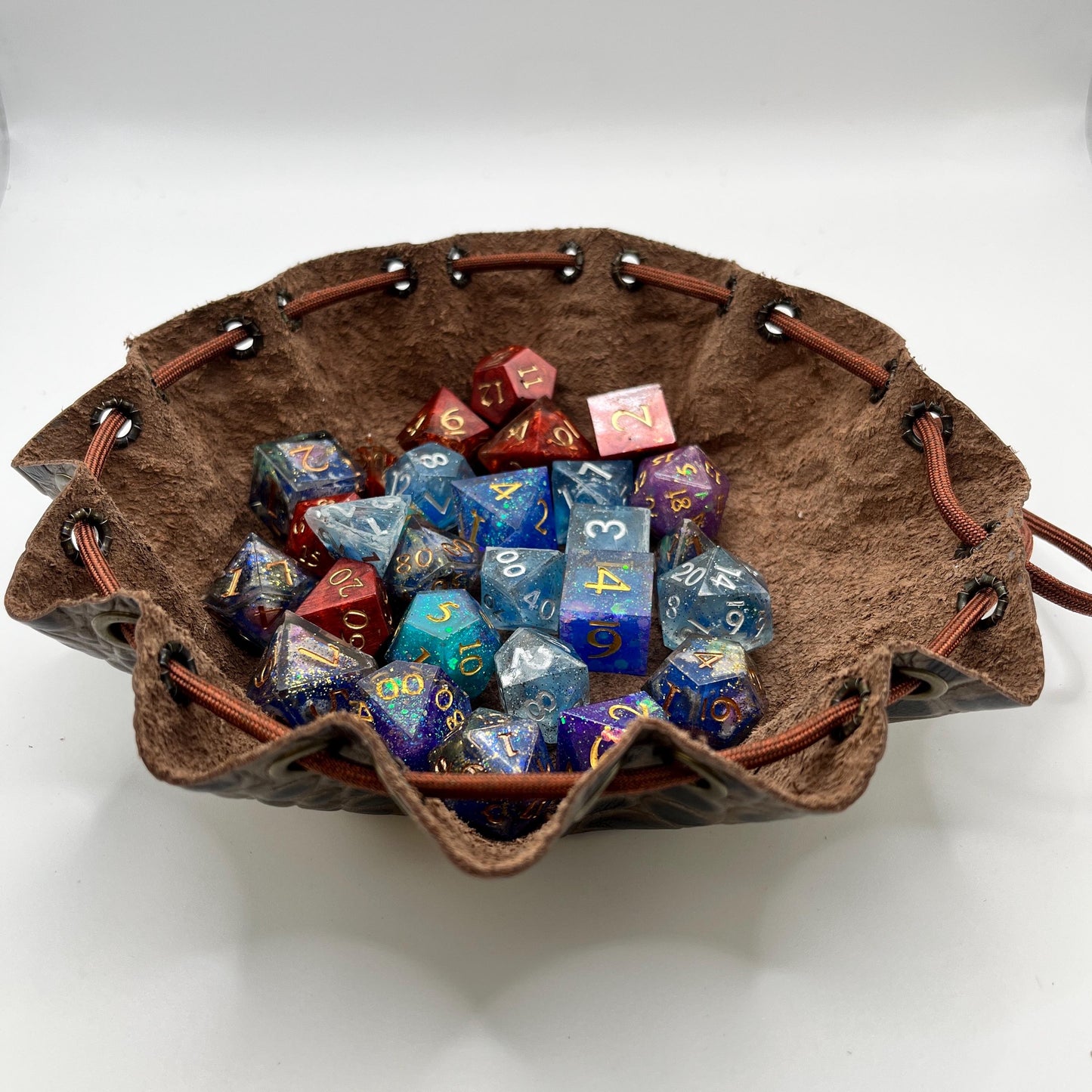 Handcrafted leather dice bag with drawstring, ideal for storing RPG dice sets. Perfect for DnD, tabletop games, or as a fantasy gift for gamers.
