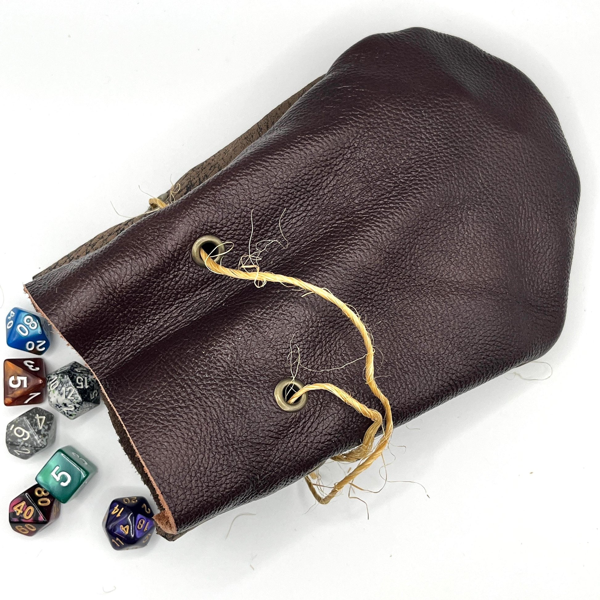 Handcrafted leather dice bag with drawstring, ideal for storing RPG dice sets. Perfect for DnD, tabletop games, or as a fantasy gift for gamers.
